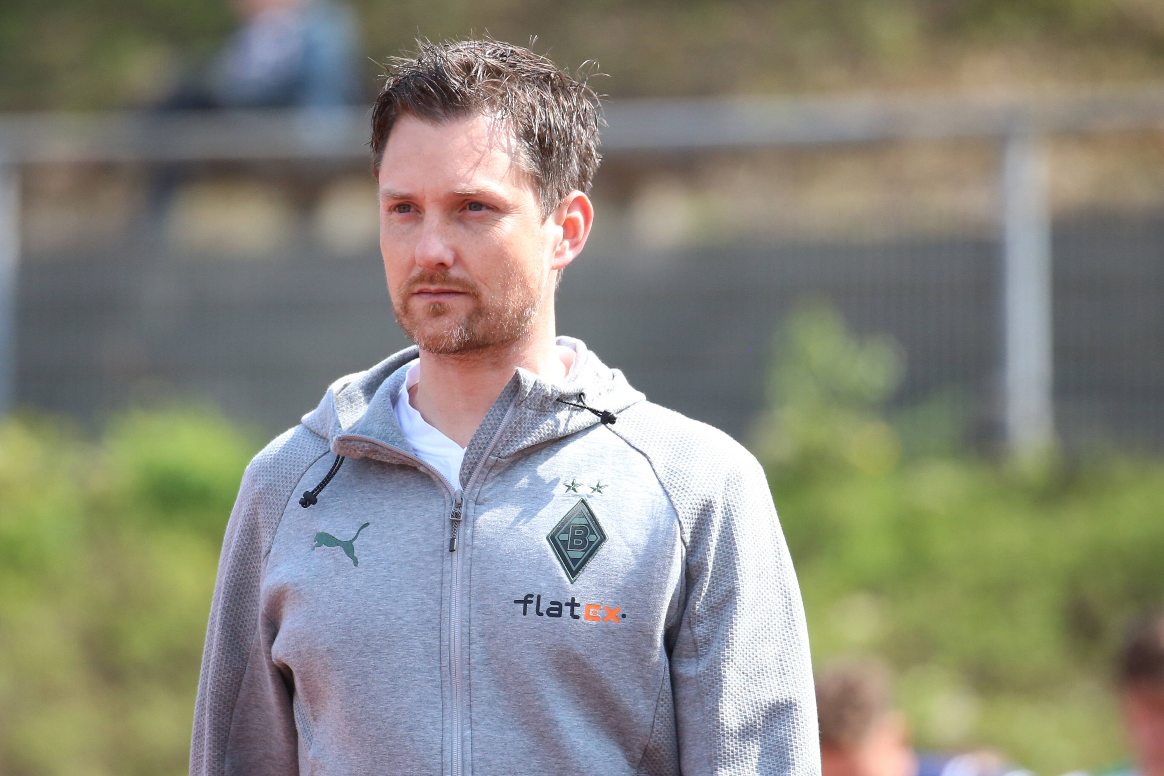 Nachwuchs-Chef Mirko Sandmöller von Borussia Mönchengladbach, hier zu sehen am 23. April 2022 im Rheydter Grenzlandstadion, droht der Abgang eines Talentes. Er schaut nach vorne, er trägt eine graue Trainingsjacke.