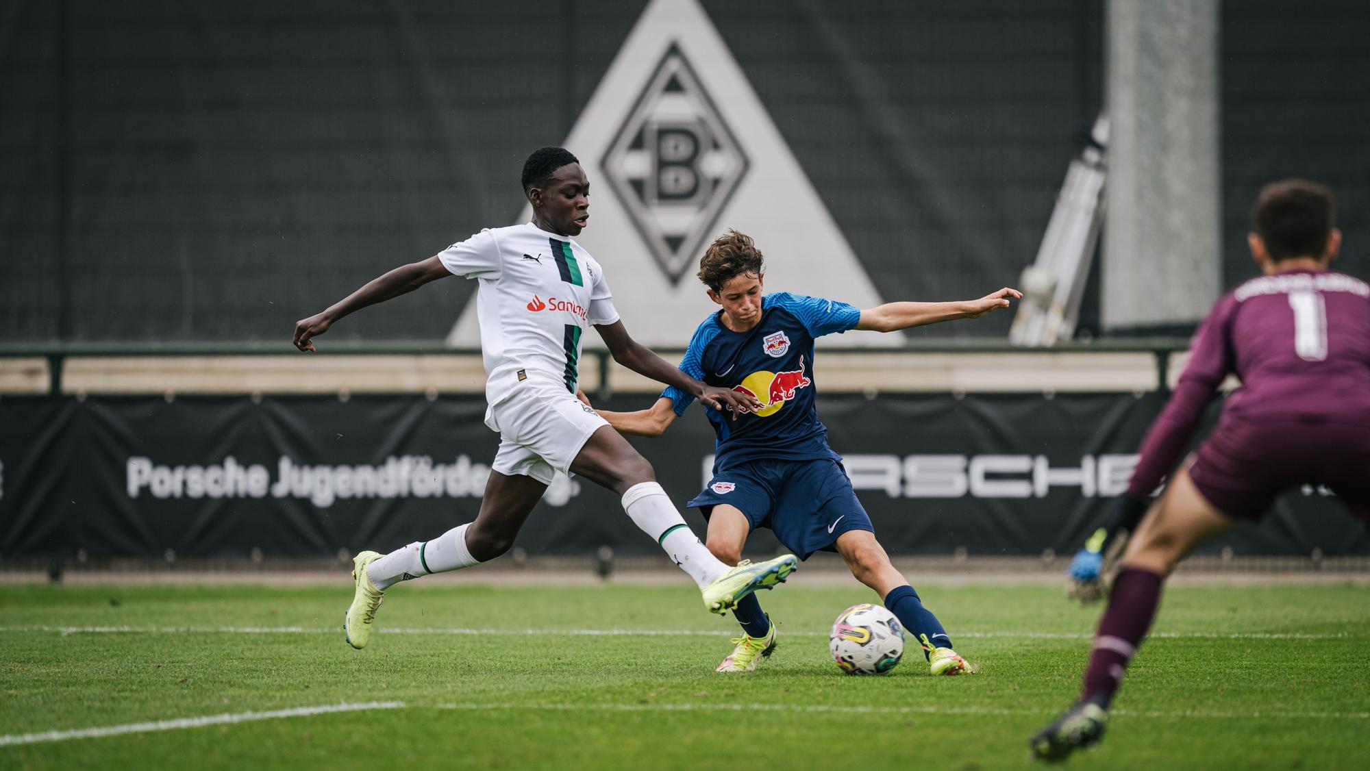 Die U15 von Borussia Mönchengladbach hat den „Porsche Fußball Cup“ 2022 in Mönchengladbach gewonnen. Das Foto stammt vom Vorrundenspiel gegen RB Salzburg am 24. September 2022. Ein Salzburger Angreifer ist im Zweikampf mit einem Gladbacher Verteidiger.