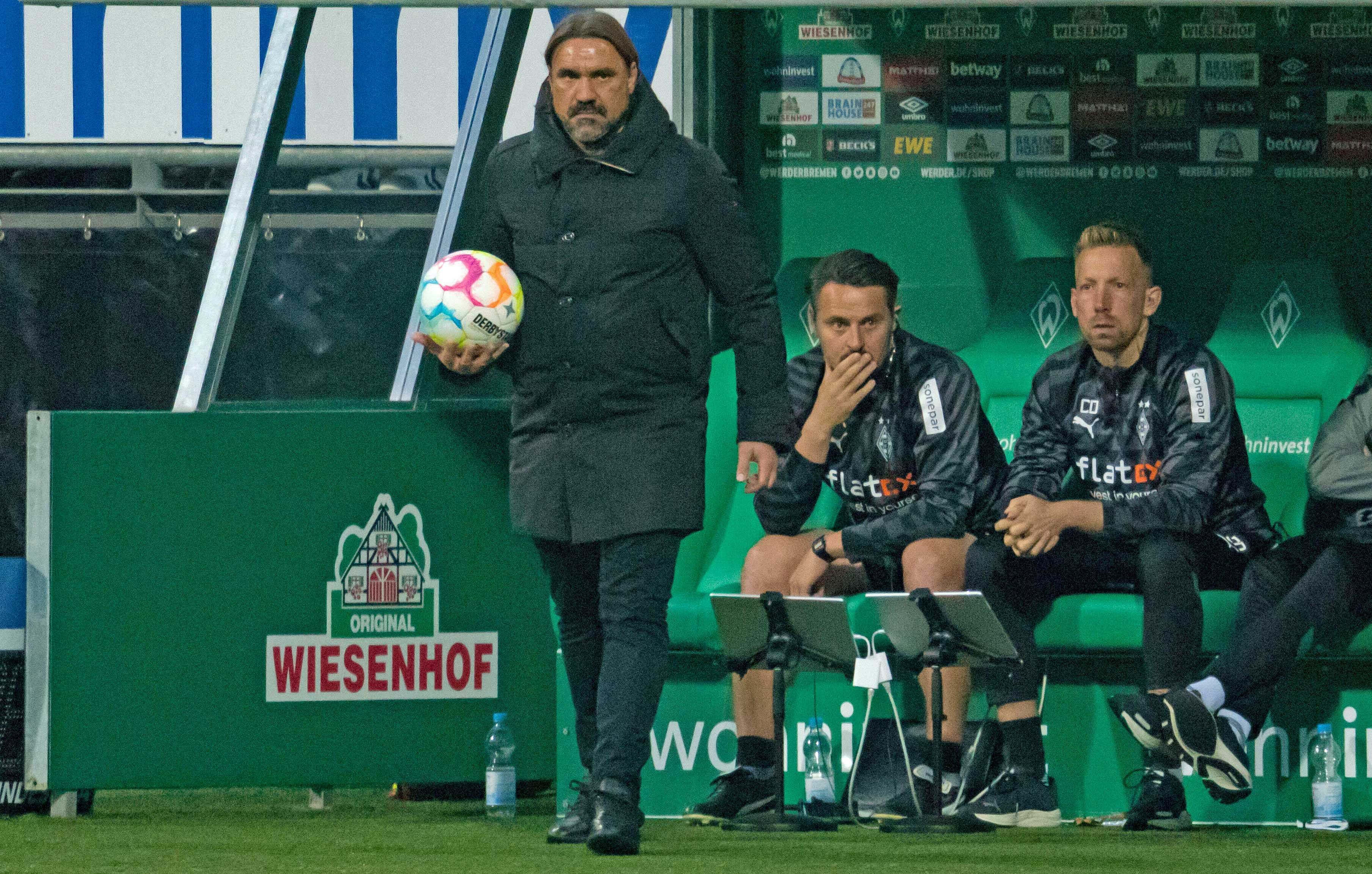 Gladbach-Trainer Daniel Farke (l.), hier zu sehen am 1. Oktober 2022 an der Seitenlinie im Bremer Weserstadion. Farke hält einen Ball in seiner rechten Hand.