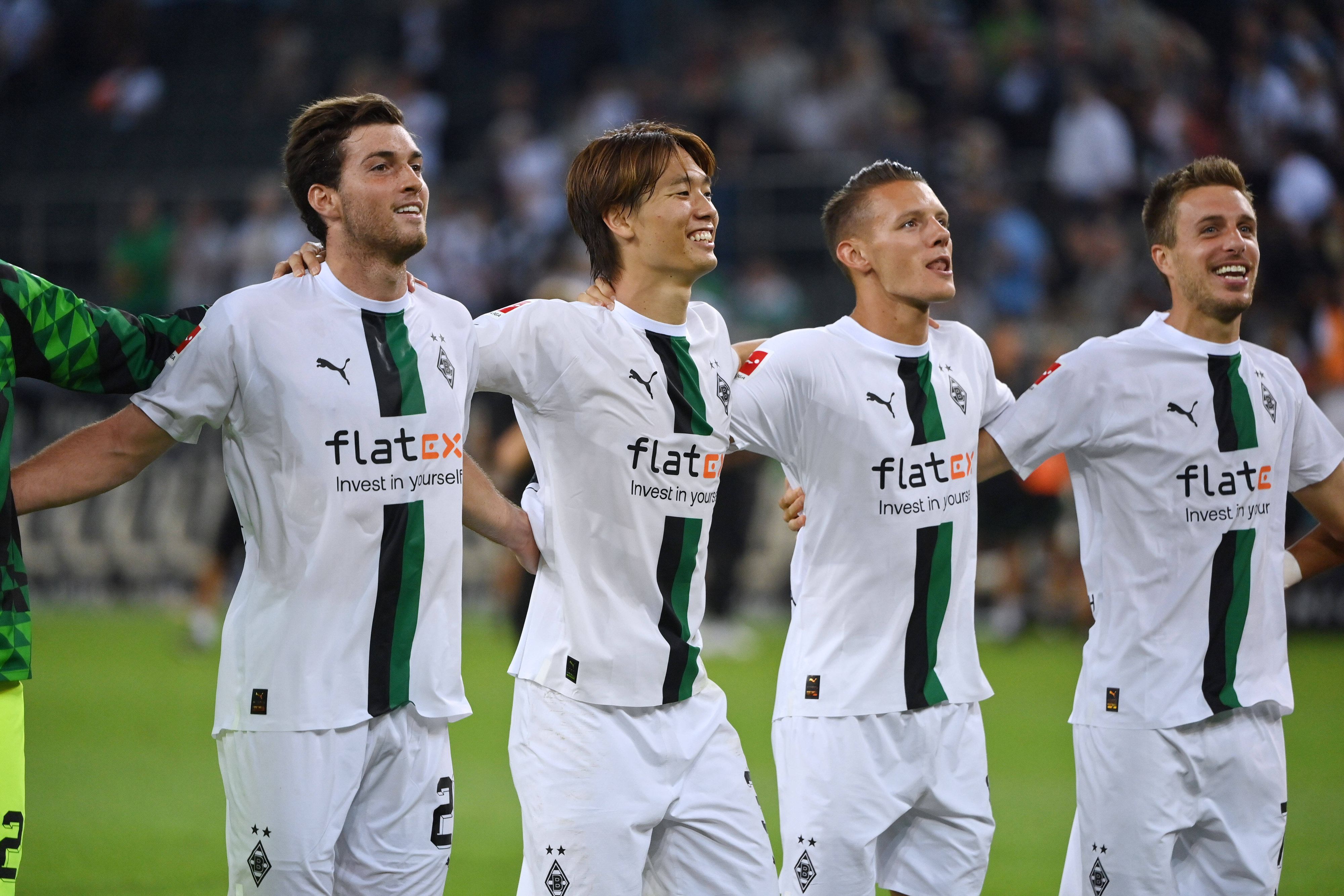 Ko Itakura und Hannes Wolf gemeinsam mit Patrick Herrmann und Joe Scally vor der Nordkurve nach dem Heimsieg gegen Hertha BSC (19. August 2022).