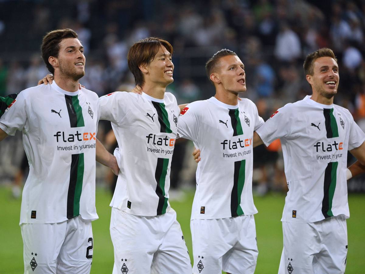 Ko Itakura und Hannes Wolf gemeinsam mit Patrick Herrmann und Joe Scally vor der Nordkurve nach dem Heimsieg gegen Hertha BSC (19. August 2022).