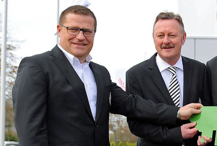 Gladbach-Manager Roland Virkus (r.) mit seinem Amts-Vorgänger Max Eberl (l.). Dieses Foto zeigt die beiden am 12. März 2019 bei einem Pressetermin im Borussia-Park. Virkus und Eberl lächeln in die Kamera.