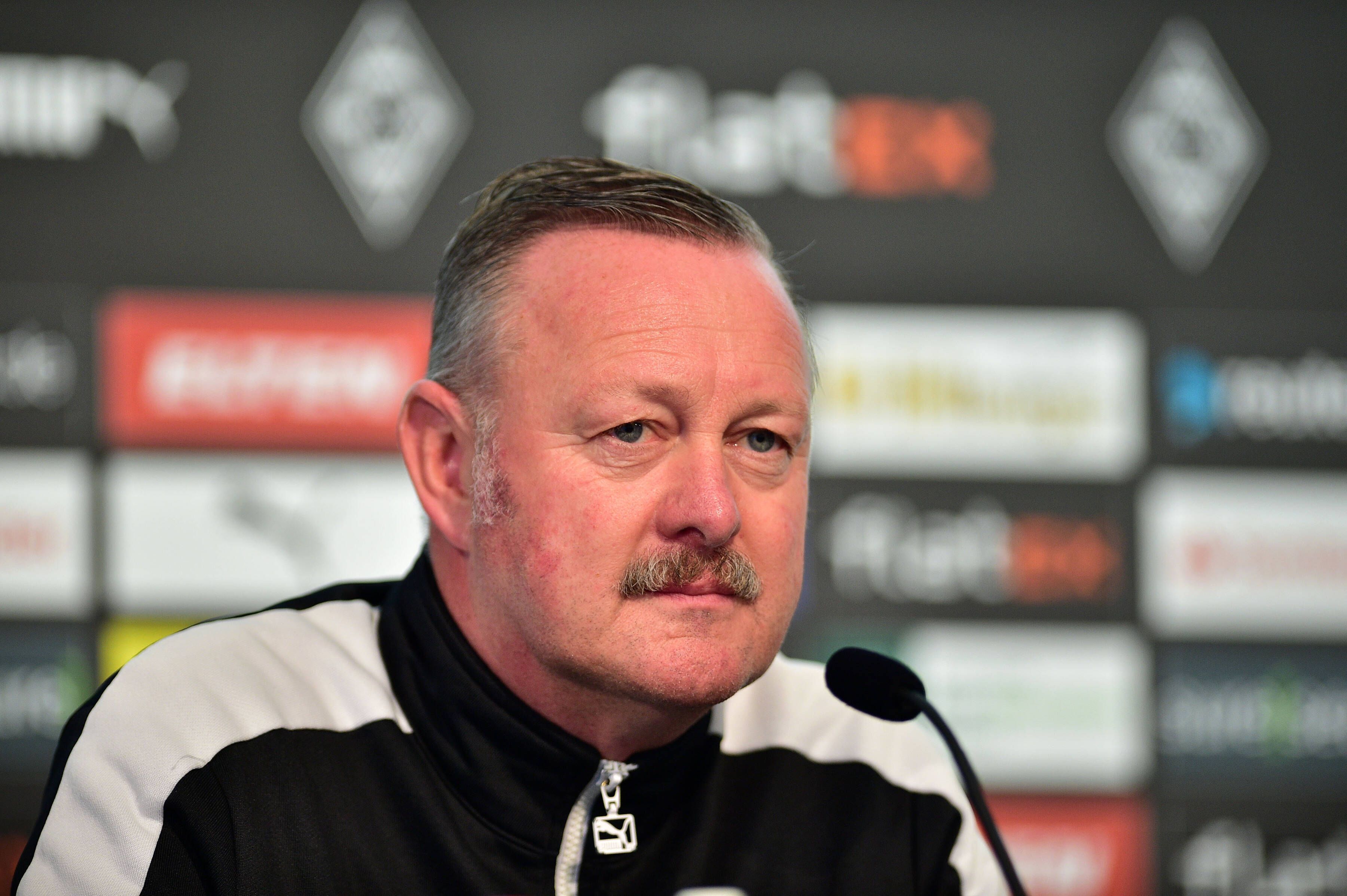 Roland Virkus, Sportdirektor von Fußball-Bundesligist Borussia Mönchengladbach. Hier ist der 55-Jährige am 7. Oktober 2022 bei der Derby-Pressekonferenz im Borussia-Park zu sehen. Virkus schaut nach vorne, er trägt eine schwarz-weiße Trainingsjacke.