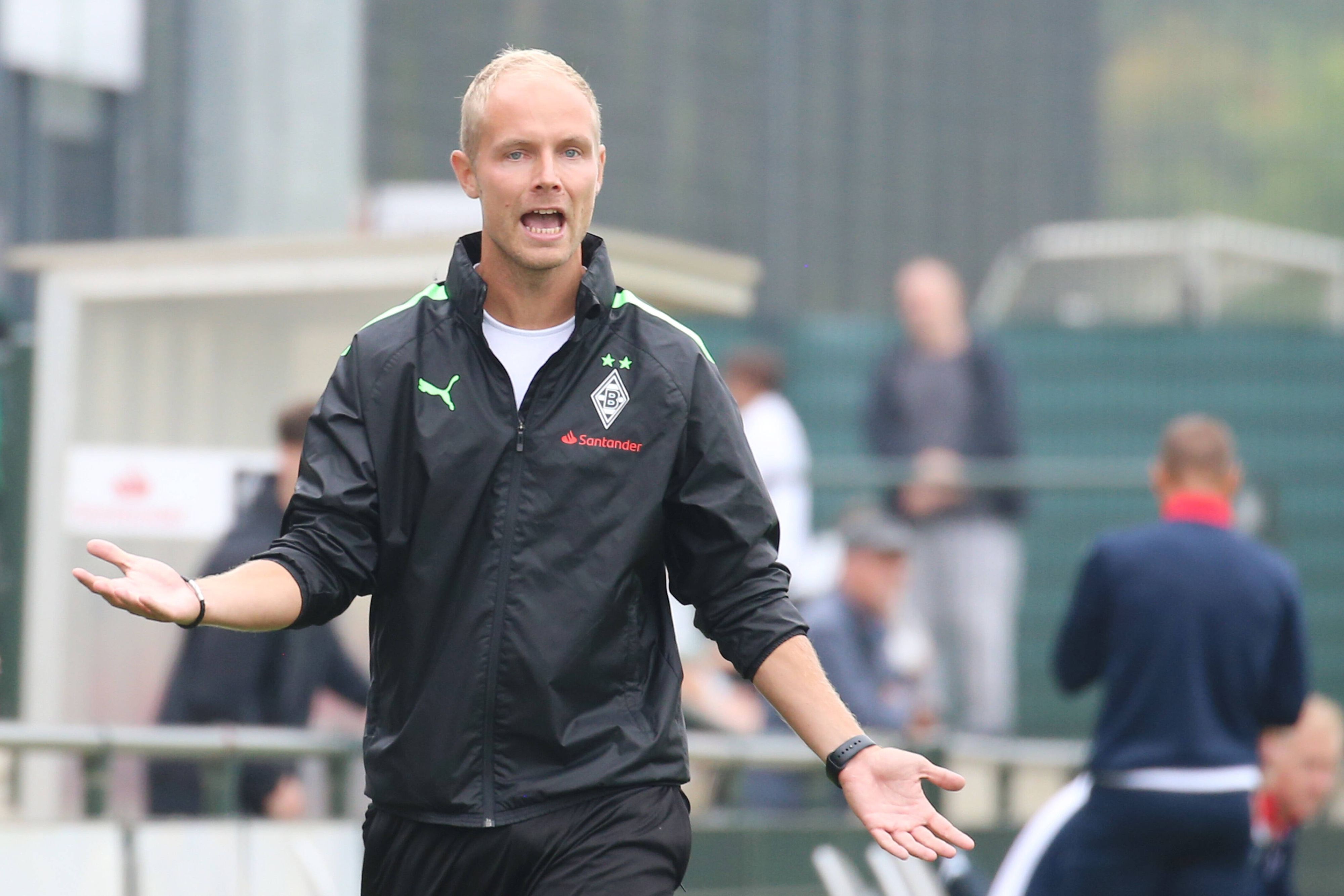 Sebastian König, Trainer der U19 von Borussia Mönchengladbach am 20. August 2022 beim A-Junioren-Bundesligaspiel gegen den Bonner SC. König gestikuliert mit den Armen und ruft verärgert.