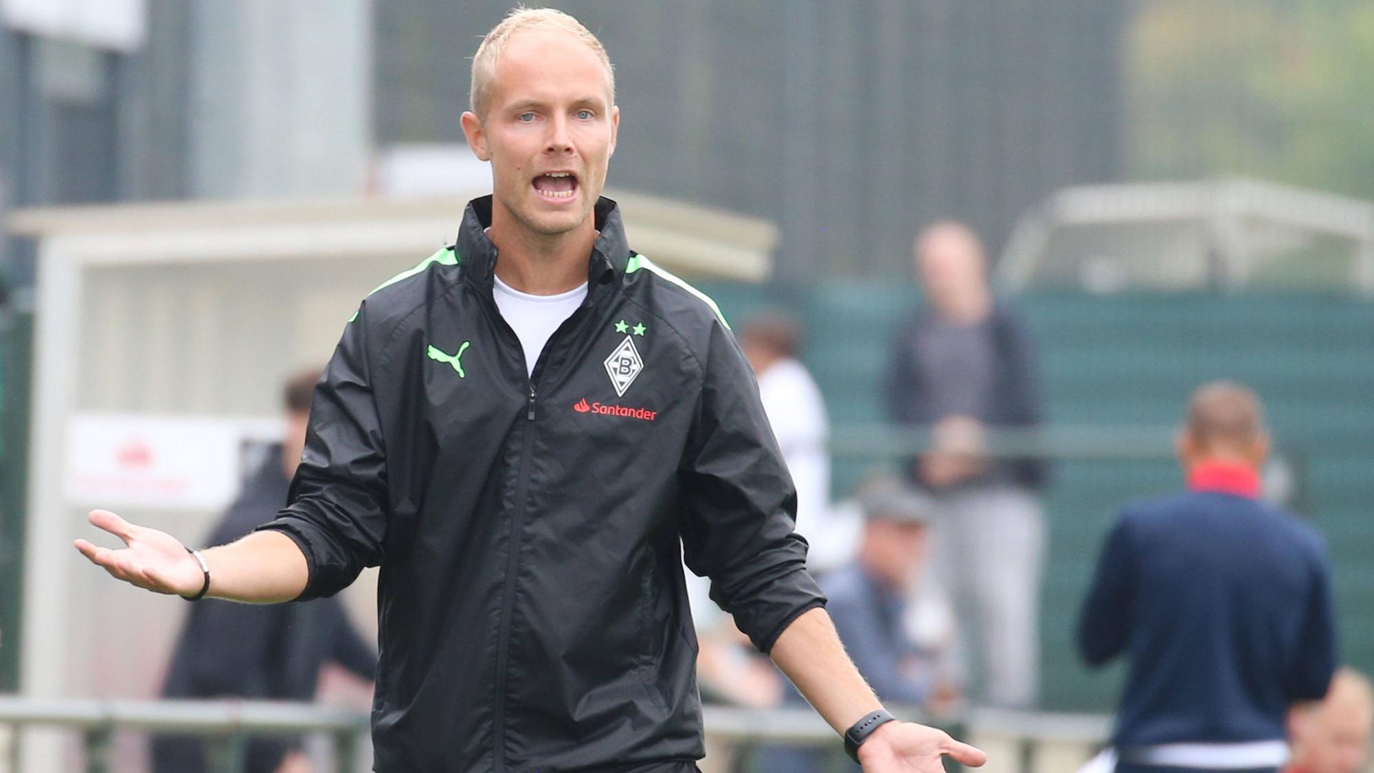 Sebastian König, Trainer der U19 von Borussia Mönchengladbach am 20. August 2022 beim A-Junioren-Bundesligaspiel gegen den Bonner SC. König gestikuliert mit den Armen und ruft verärgert.