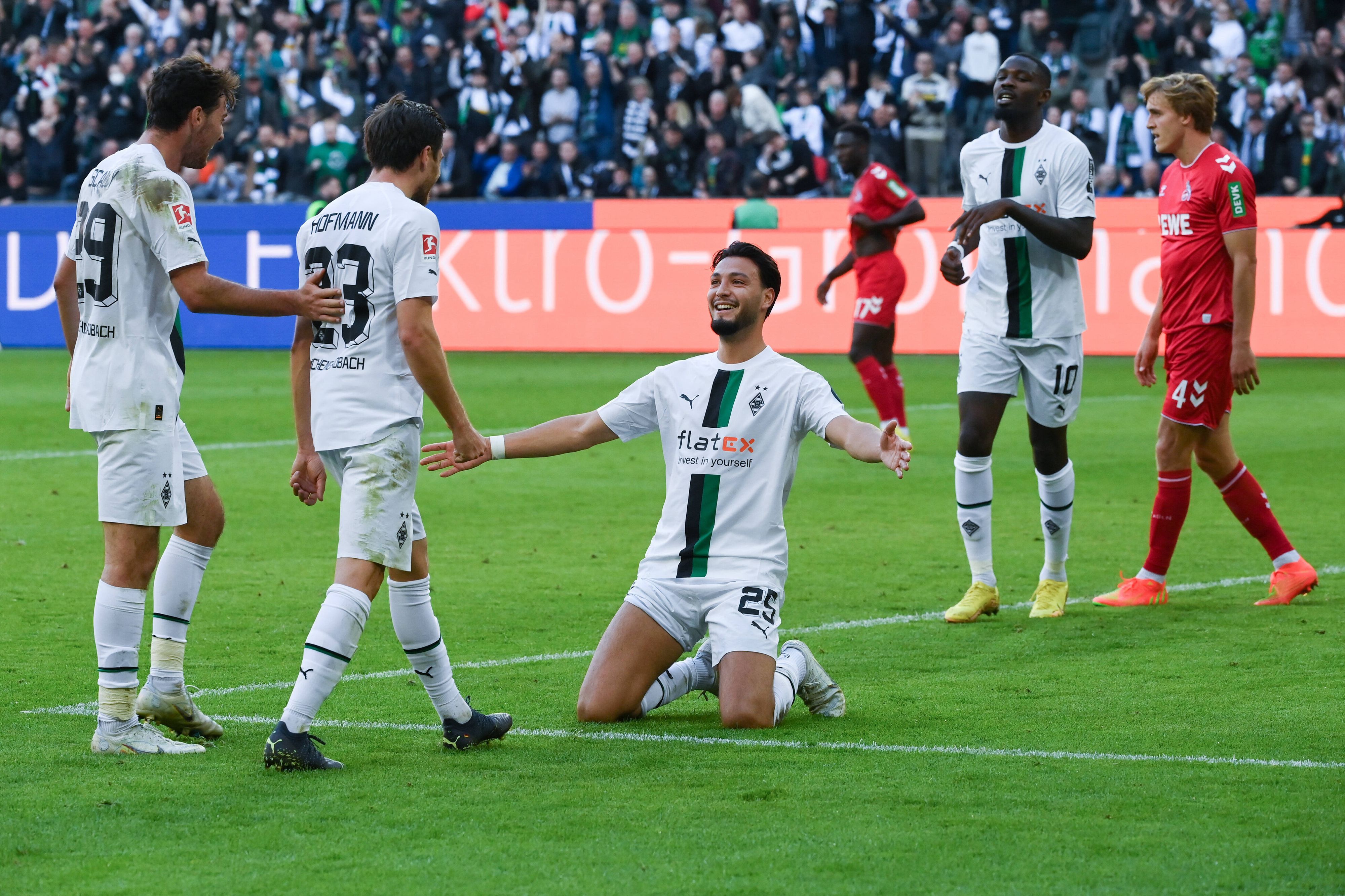 Torschütze Ramy Bensebaini (kniend) jubelt mit Joe Scally (l.), Jonas Hofmann (2. v. l.) und Marcus Thuram (2. v. r.) über seinen Treffer zum 4:1 für Borussia Mönchengladbach gegen den 1. FC Köln am 9. Oktober 2022.