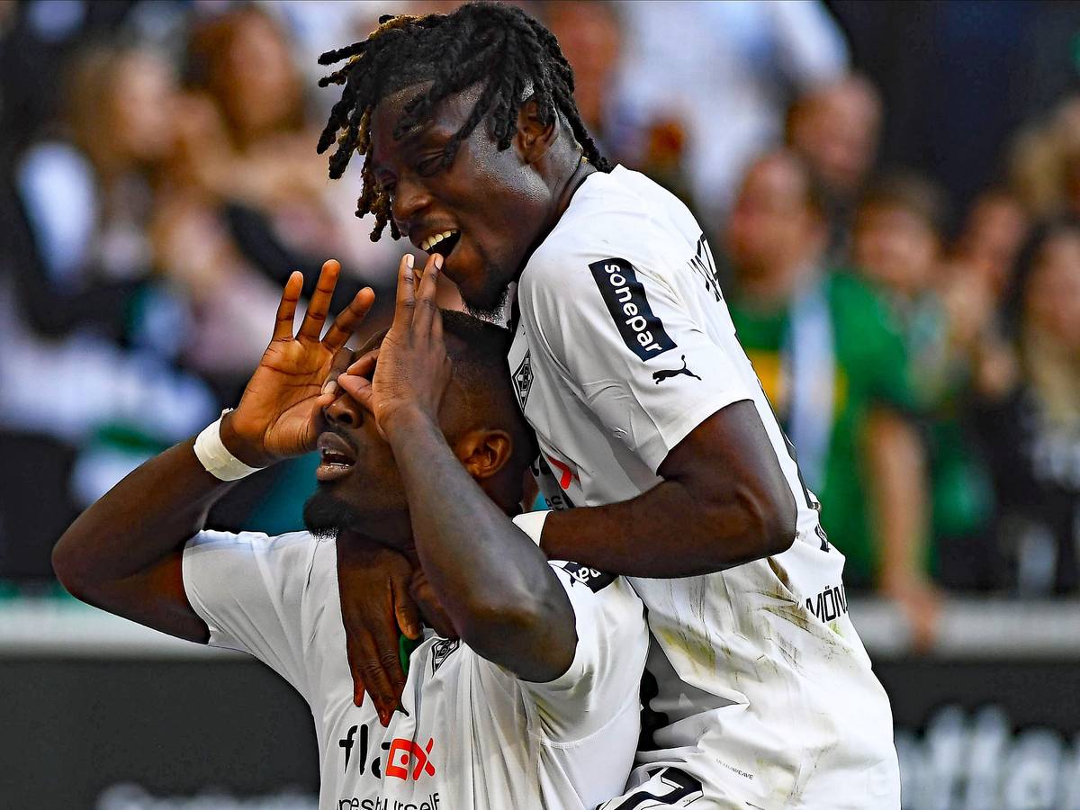 Stürmer Marcus Thuram (l.) von Borussia Mönchengladbach hat beim Derbysieg gegen den 1. FC Köln am Sonntag (9. Oktober 2022) zum 5:2-Endstand getroffen. Das Foto zeigt ihn beim Torjubel, bei dem er den Brillenjubel von Ex-Köln-Profi Anthony Modest imitiert. Teamkollege Manu Koné (r.) jubelt mit. Thuram macht eine Geste mit seinen Händen.