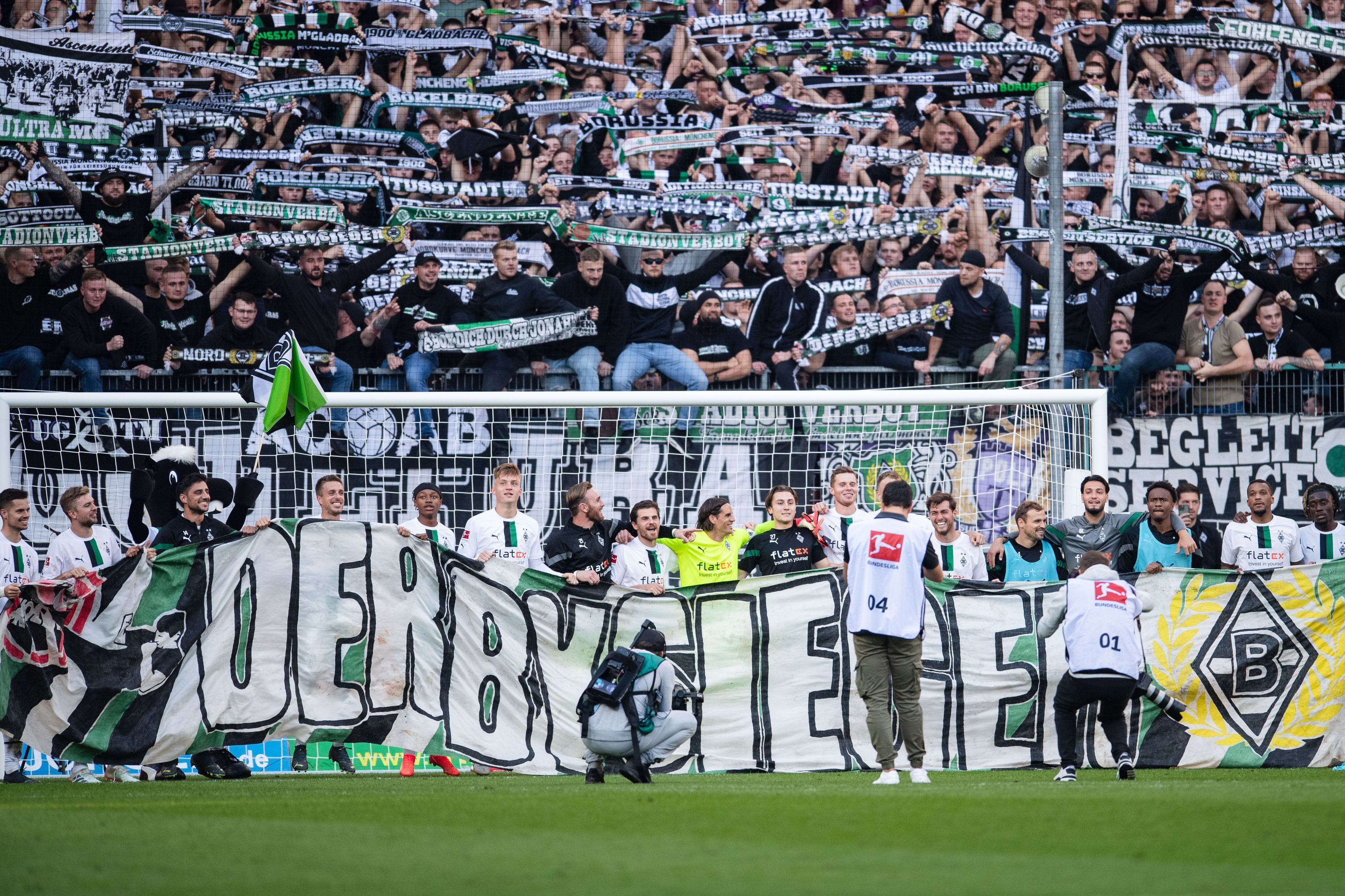 Die Spieler von Fußball-Bundesligist Borussia Mönchengladbach feiern den Derbysieg (9. Oktober 2022) gegen den 1. FC Köln im Borussia. Allerdings plagen die Elf vom Niederrhein im Anschluss Personalsorgen. Zu sehen ist ein Banner mit dem Aufdruck Derbysieger.