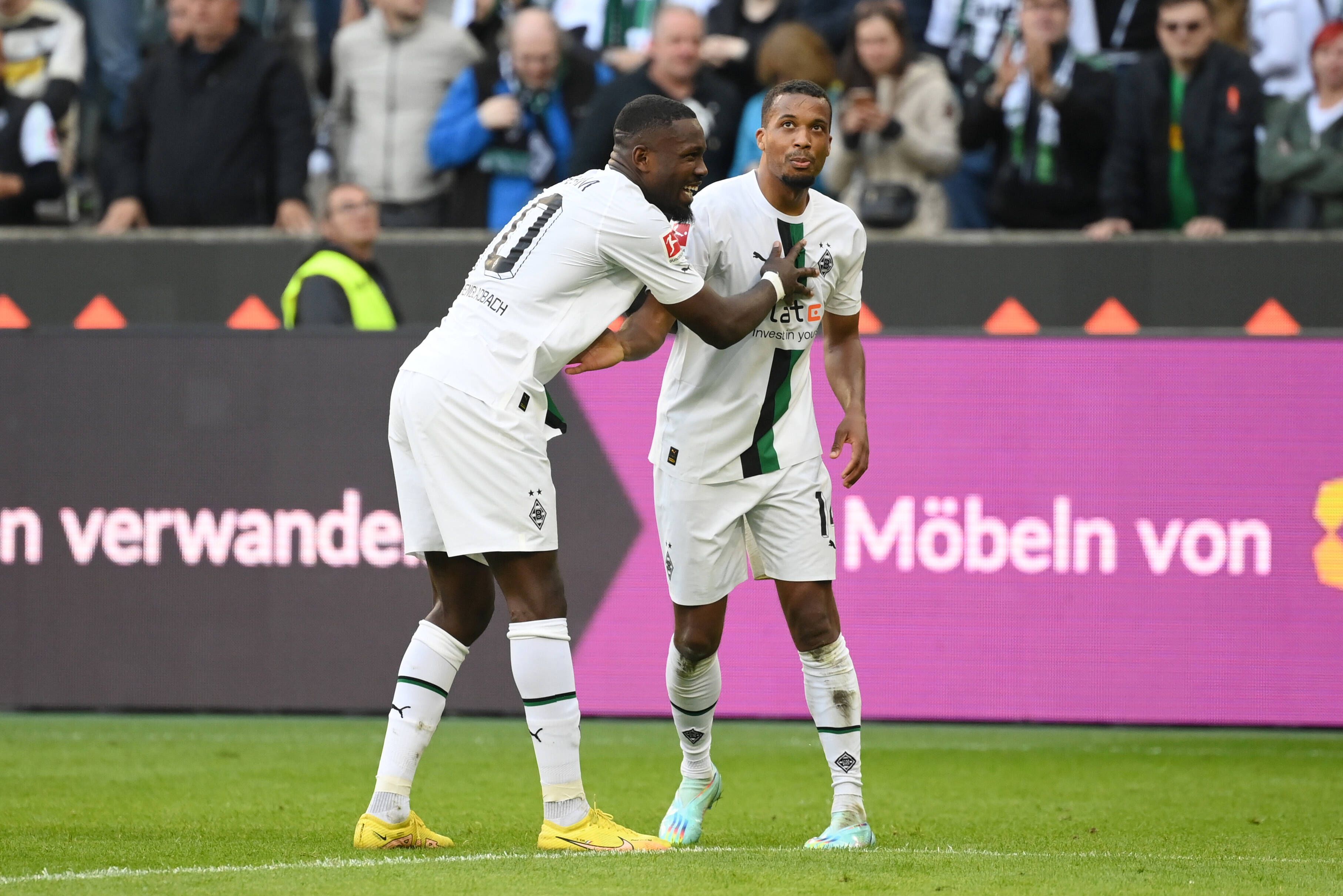Marcus Thuram (l.) und Alassane Plea (r.) jubeln gemeinsam über Thurams Treffer zum 5:2 für Borussia Mönchengladbach gegen den 1. FC Köln am 9. Oktober 2022.