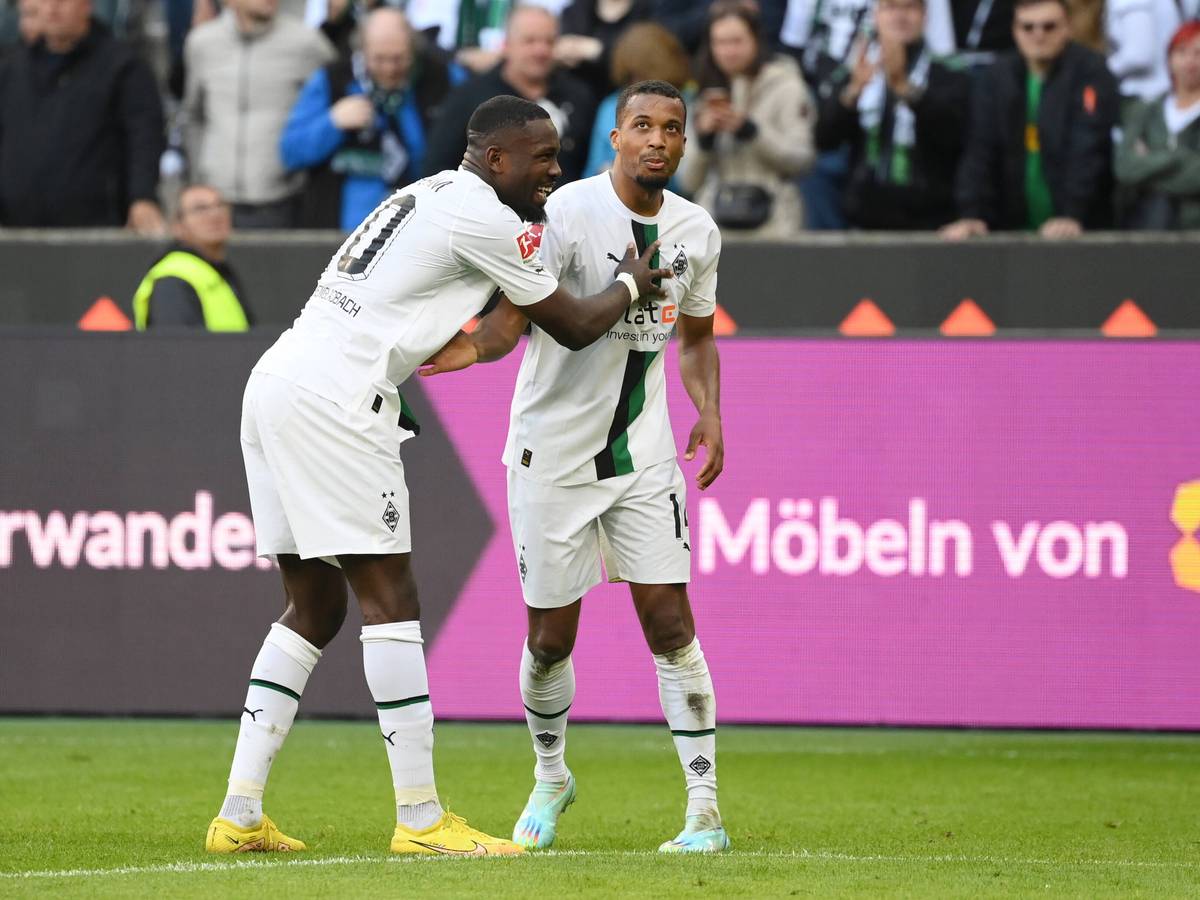Marcus Thuram (l.) und Alassane Plea (r.) jubeln gemeinsam über Thurams Treffer zum 5:2 für Borussia Mönchengladbach gegen den 1. FC Köln am 9. Oktober 2022.