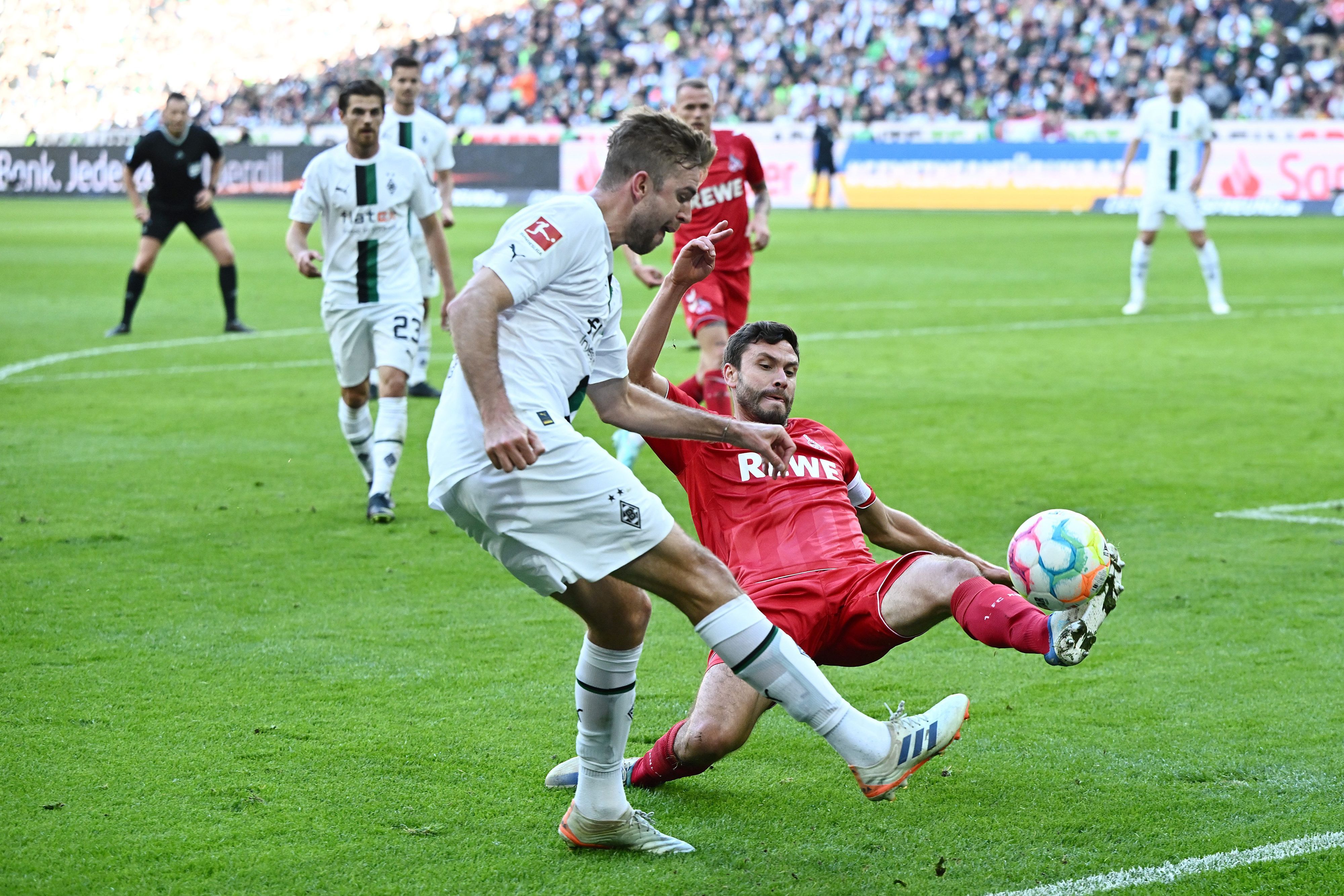 Christoph Kramer von Borussia Mönchengladbach schlägt eine Flanke im Derby gegen den 1. FC Köln am 9. Oktober 2022, Gegenspieler Jonas Hector will das verhindern.
