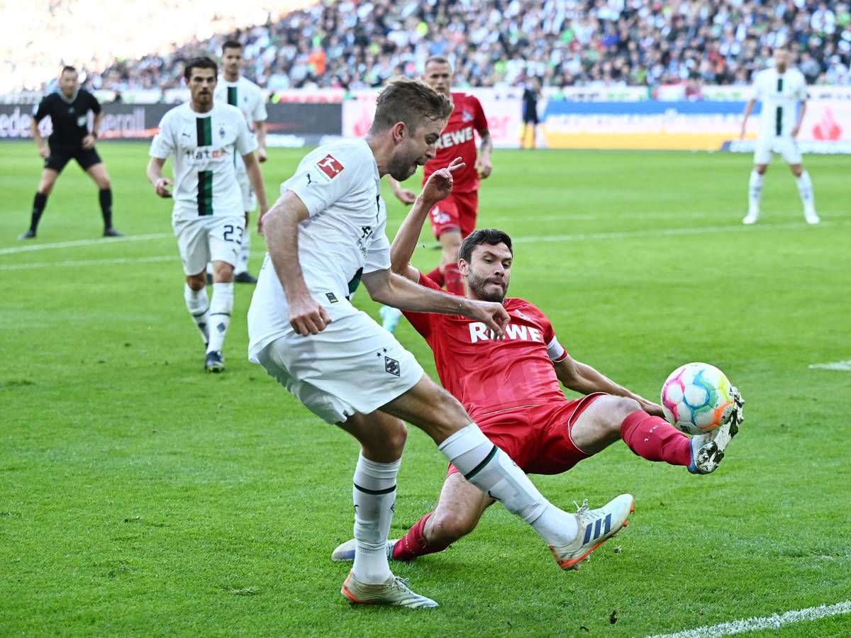 Christoph Kramer von Borussia Mönchengladbach schlägt eine Flanke im Derby gegen den 1. FC Köln am 9. Oktober 2022, Gegenspieler Jonas Hector will das verhindern.