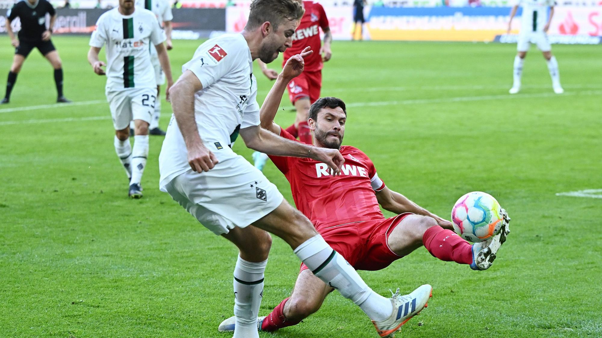 Christoph Kramer von Borussia Mönchengladbach schlägt eine Flanke im Derby gegen den 1. FC Köln am 9. Oktober 2022, Gegenspieler Jonas Hector will das verhindern.