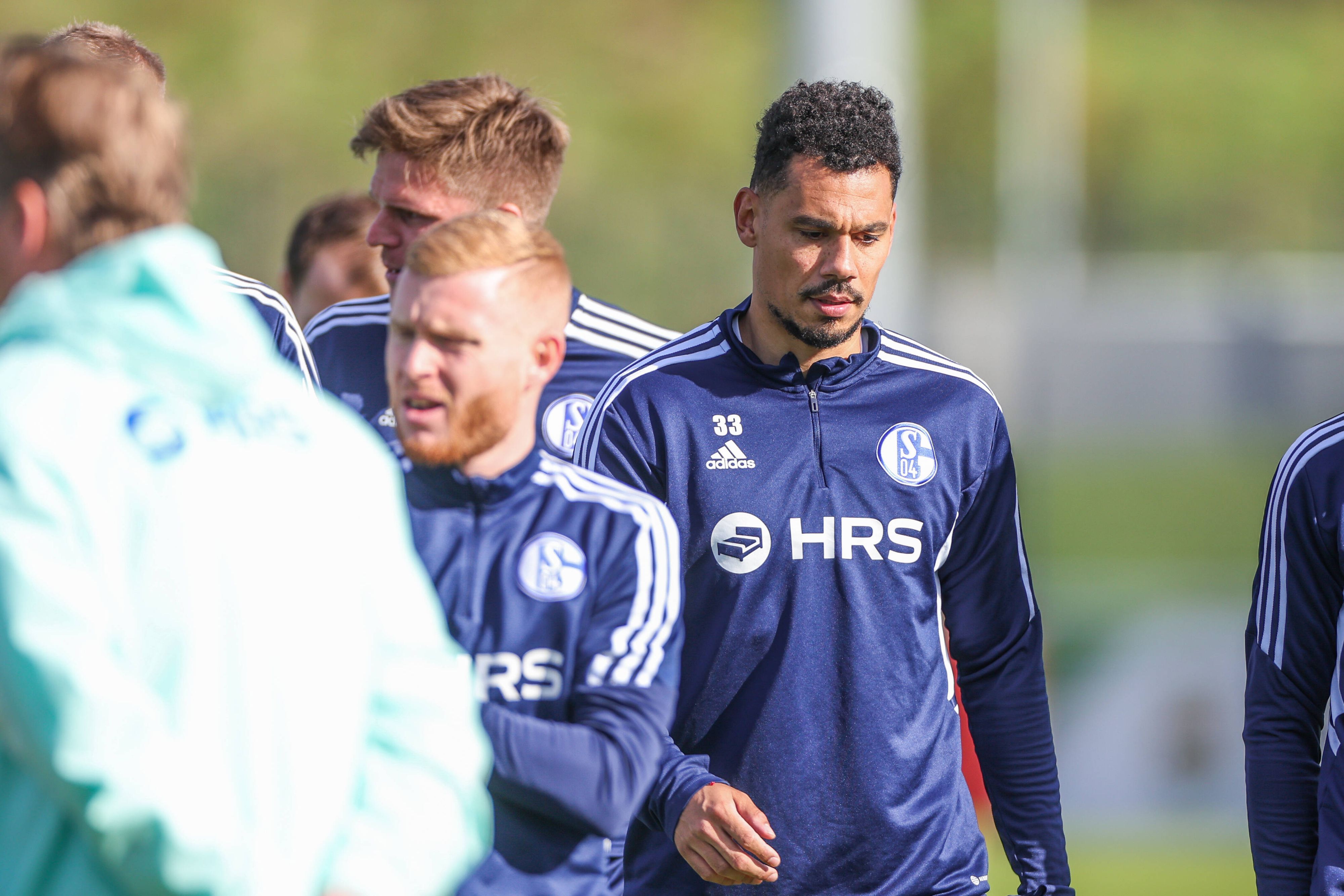 Ex-Gladbach-Profi Timothee Kolodziejczak (r.), hier zu sehen am 11. Oktober 2022 in Gelsenkirchen, spielt aktuell bei Fußball-Bundesligist Schalke 04 vor. Kolodziejczak trägt Schalke-Trainingssachen und blickt zu Boden.