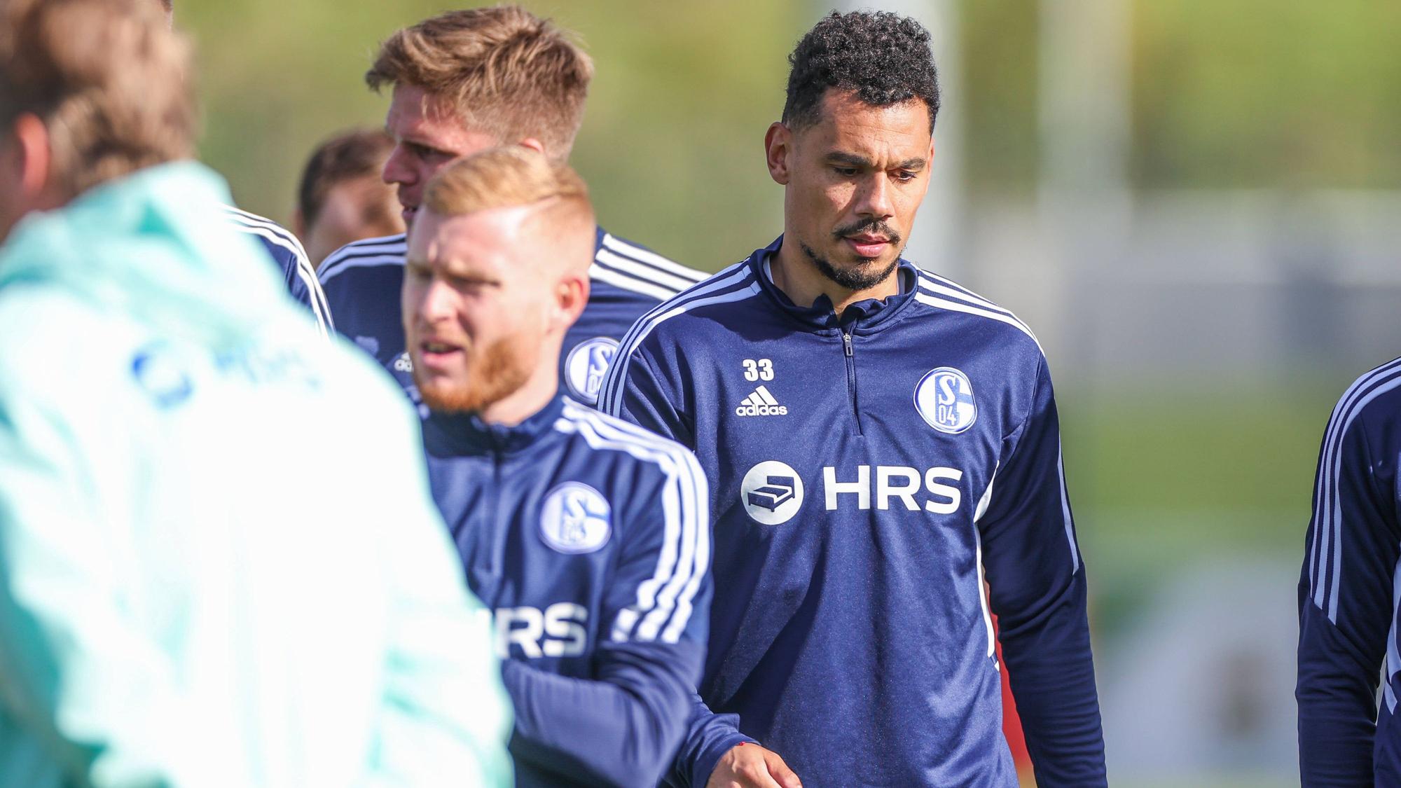 Ex-Gladbach-Profi Timothee Kolodziejczak (r.), hier zu sehen am 11. Oktober 2022 in Gelsenkirchen, spielt aktuell bei Fußball-Bundesligist Schalke 04 vor. Kolodziejczak trägt Schalke-Trainingssachen und blickt zu Boden.