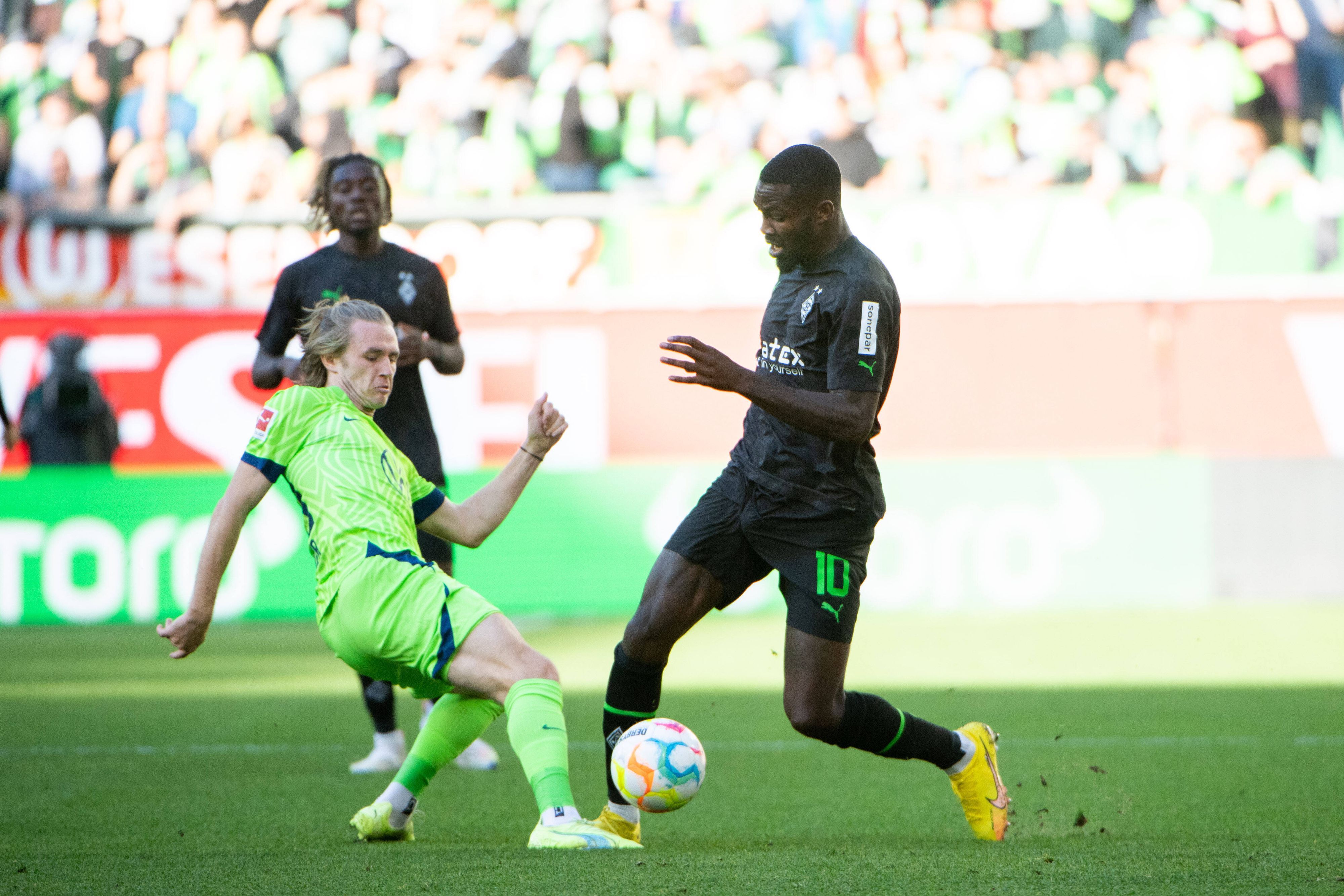 Gladbach-Stürmer Marcus Thuram (r.) im Zweikampf mit Patrick Wimmer (l.) vom VfL Wolfsburg während des Bundesliga-Duells am Samstag (15. Oktober 2022) in der Autostadt. Beide Spielen haben den Ball im Blick.