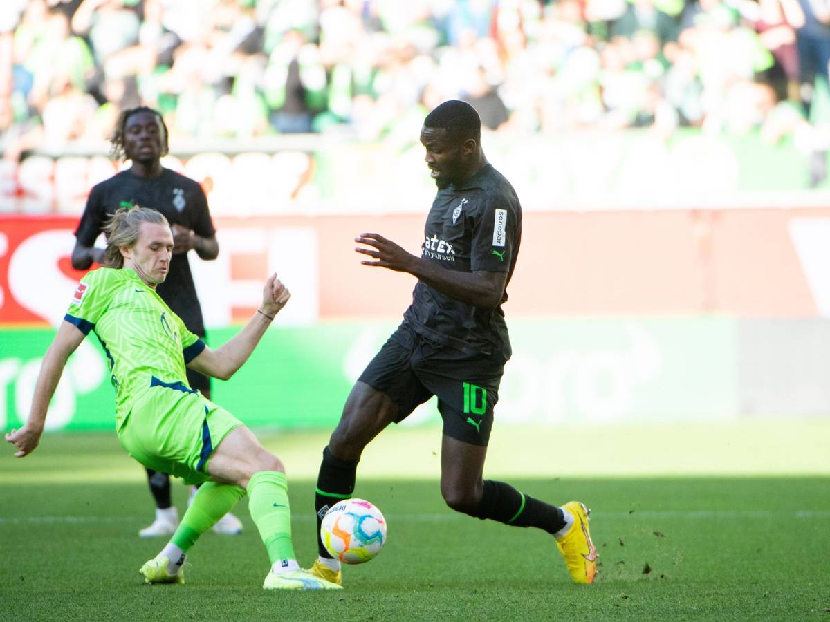 Gladbach-Stürmer Marcus Thuram (r.) im Zweikampf mit Patrick Wimmer (l.) vom VfL Wolfsburg während des Bundesliga-Duells am Samstag (15. Oktober 2022) in der Autostadt. Beide Spielen haben den Ball im Blick.