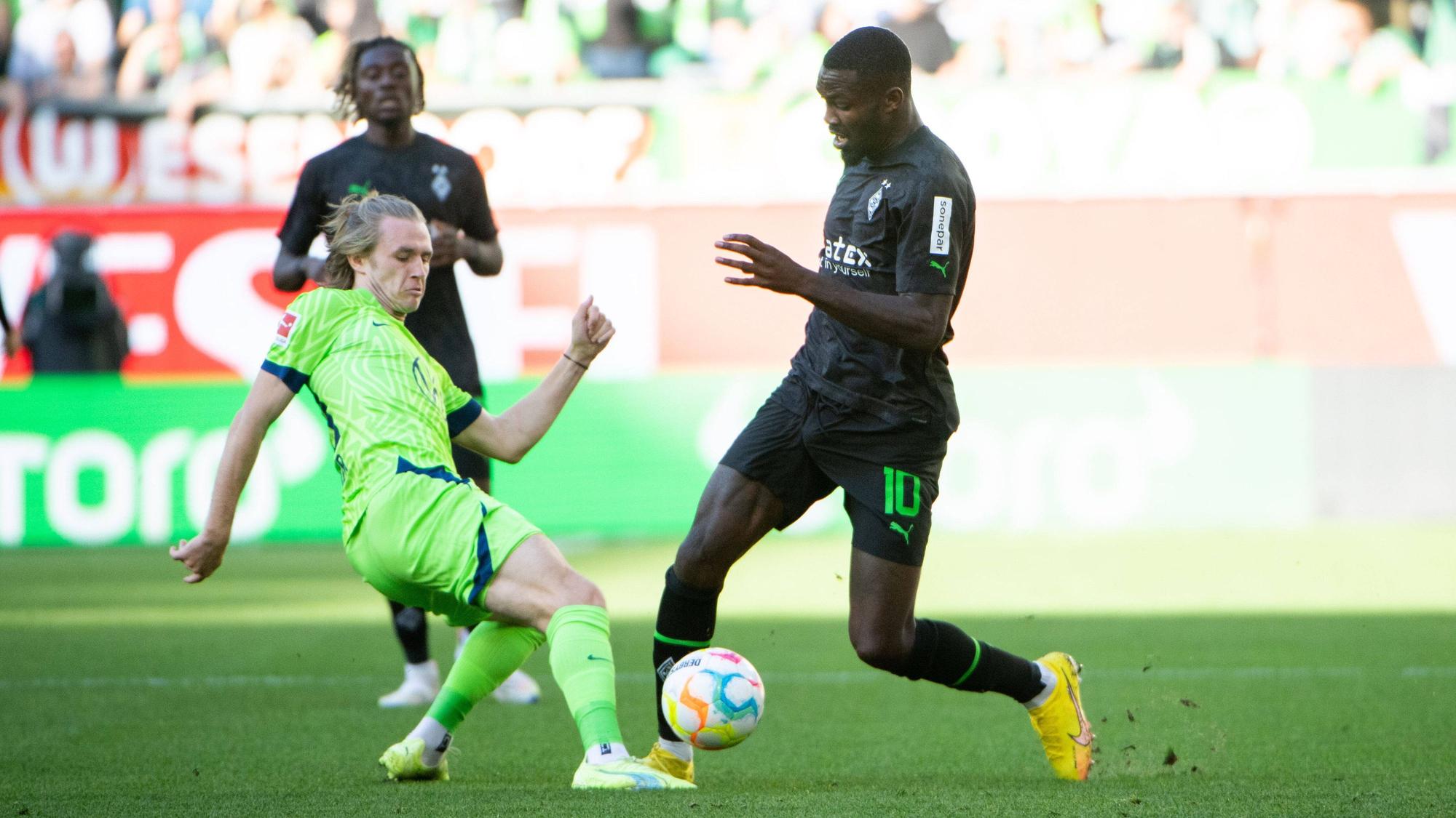 Gladbach-Stürmer Marcus Thuram (r.) im Zweikampf mit Patrick Wimmer (l.) vom VfL Wolfsburg während des Bundesliga-Duells am Samstag (15. Oktober 2022) in der Autostadt. Beide Spielen haben den Ball im Blick.