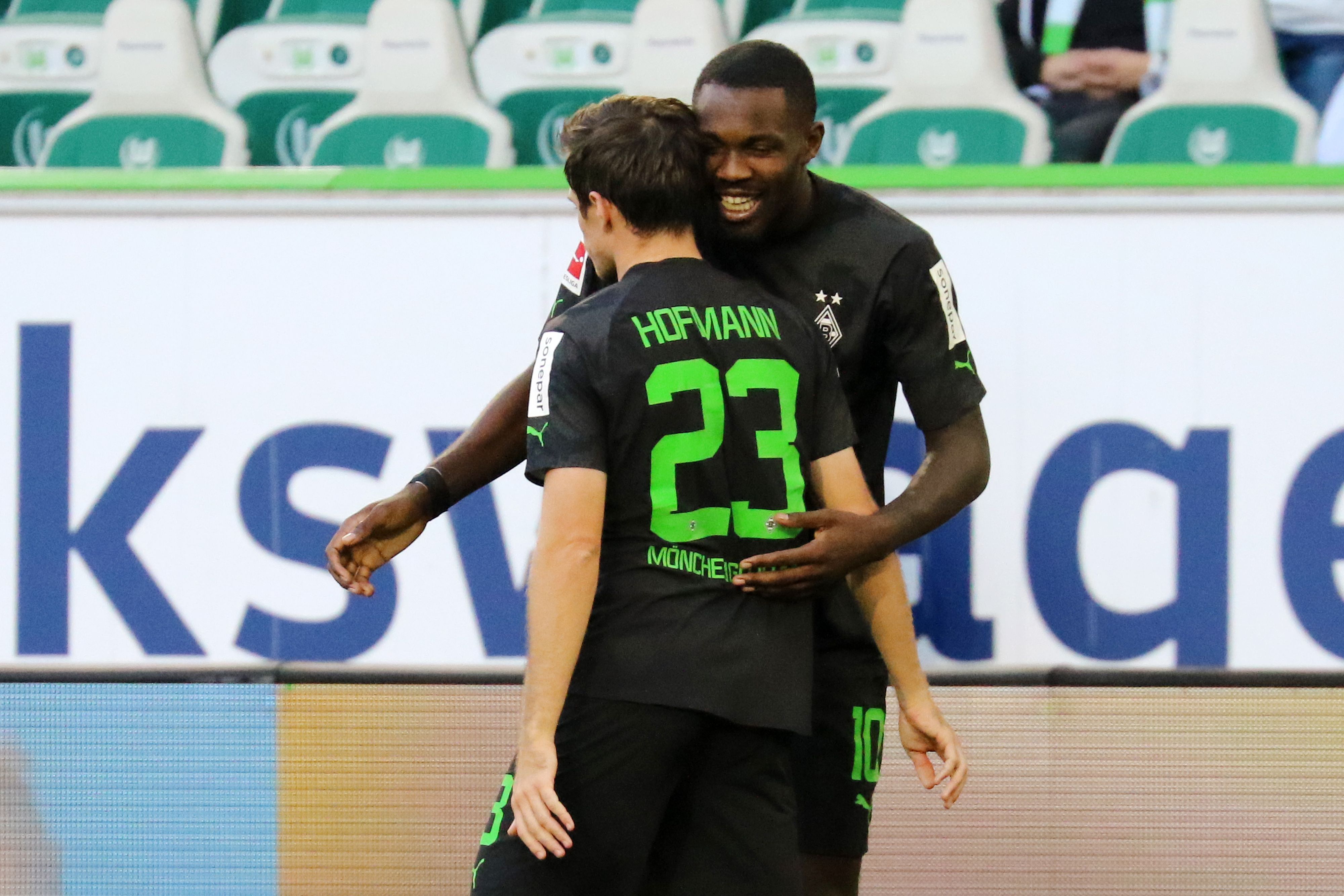Gladbach-Stürmer Marcus Thuram bejubelt gemeinsam mit seinem Teamkollegen Jonas Hofmann einen seiner beiden Treffer beim 2:2 im Bundesliga-Duell (15. Oktober 2022) in Wolfsburg. Die beiden Spieler umarmen sich.