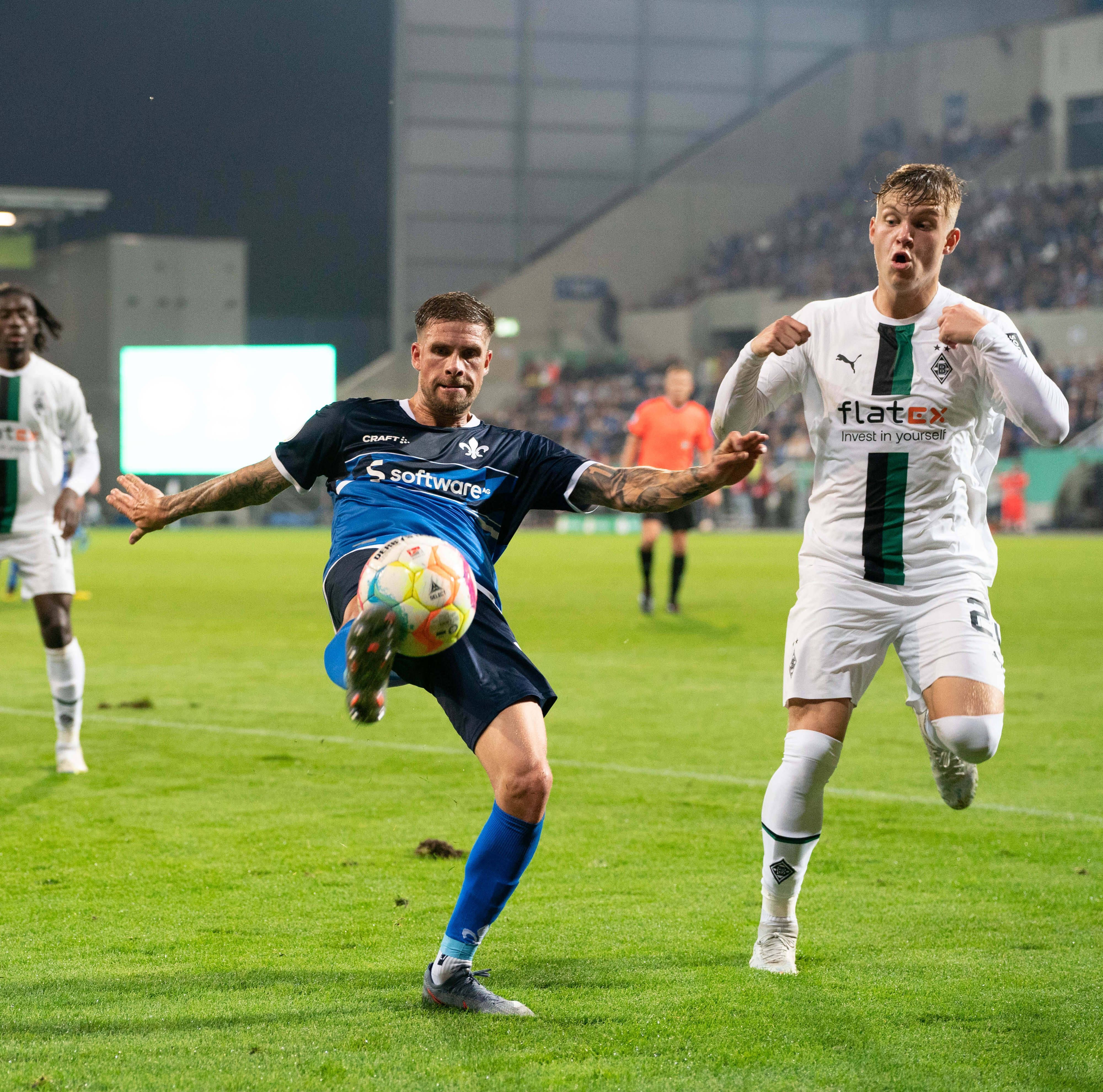 Luca Netz von Borussia Mönchengladbach (r.) im Zweikampf mit Tobias Kempe vom SV Darmstadt 98 beim DFB-Pokal-Spiel am 18. Oktober 2022.