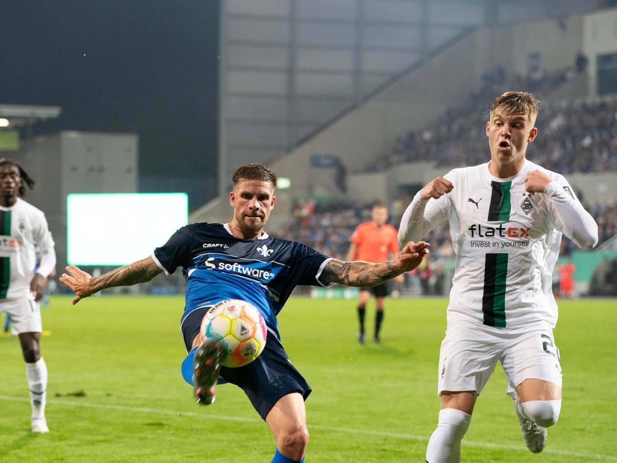 Luca Netz von Borussia Mönchengladbach (r.) im Zweikampf mit Tobias Kempe vom SV Darmstadt 98 beim DFB-Pokal-Spiel am 18. Oktober 2022.
