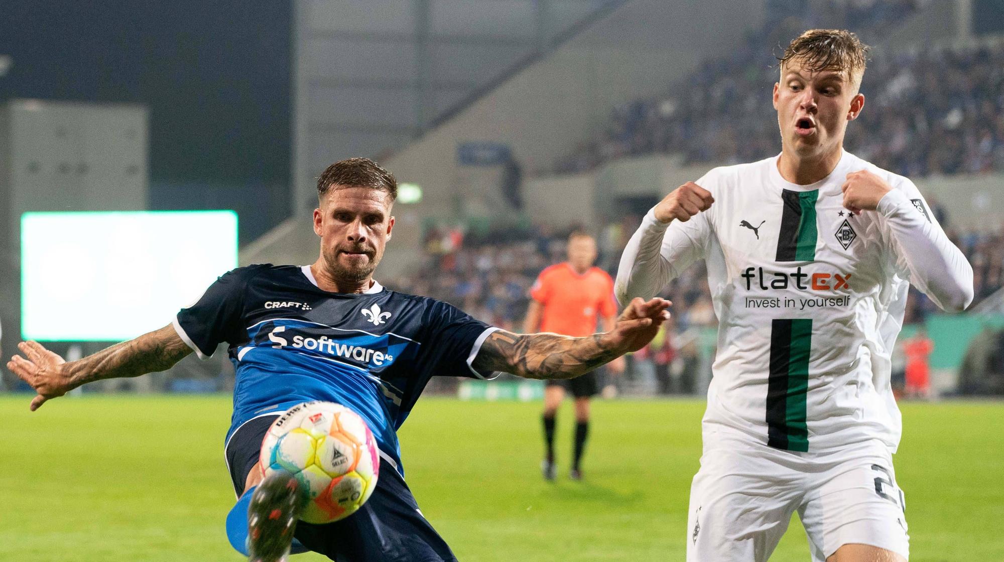 Luca Netz von Borussia Mönchengladbach (r.) im Zweikampf mit Tobias Kempe vom SV Darmstadt 98 beim DFB-Pokal-Spiel am 18. Oktober 2022.