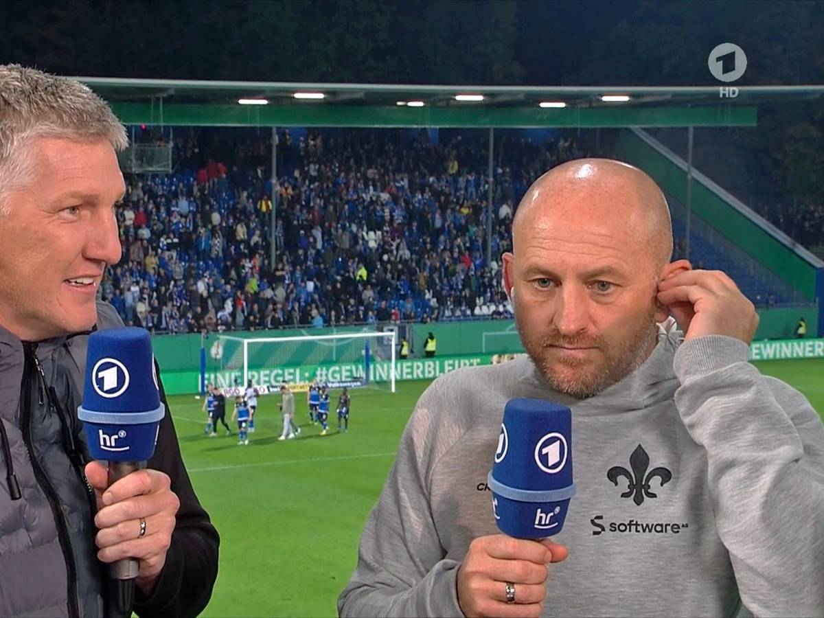 Weltmeister und ARD-Experte Bastian Schweinsteiger (l.) im Gespräch mit Darmstadt-Trainer Torsten Lieberknecht nach dem DFB-Pokal-Spiel der Lilien gegen Borussia Mönchengladbach am 18. Oktober 2022. Beide halten jeweils ein Mikrofon in der Hand.