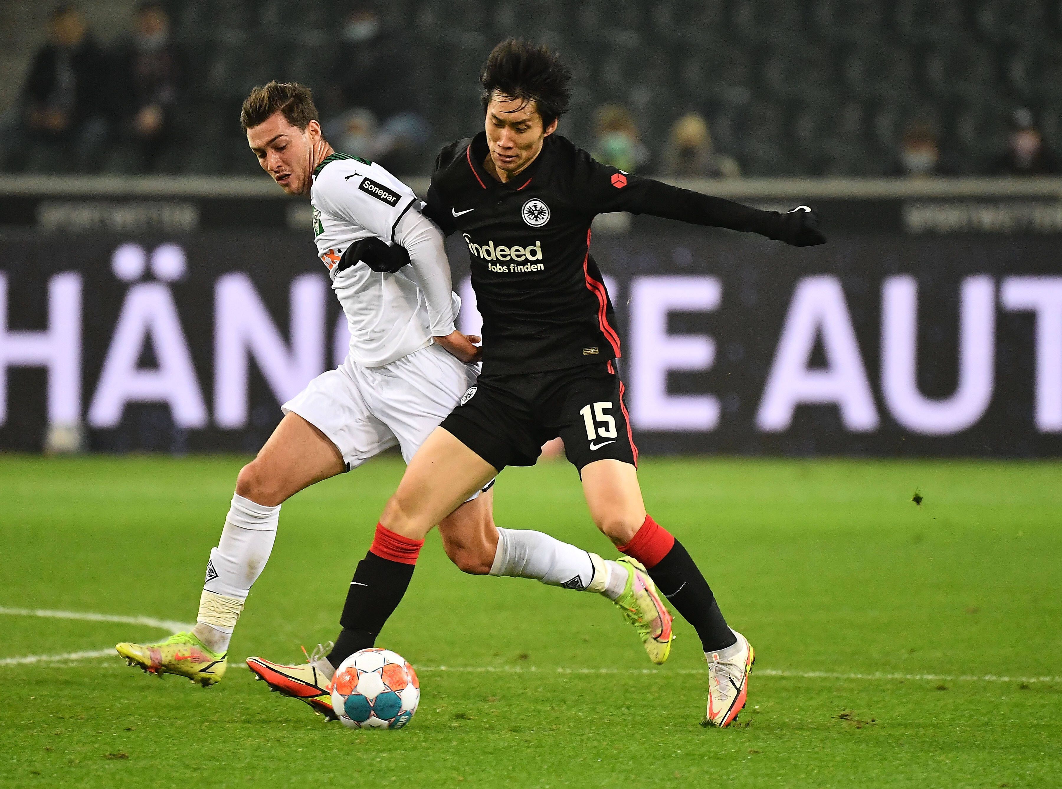 Joe Scally von Borussia Mönchengladbach (l.) im Zweikampf mit Daichi Kamada von Borussia Mönchengladbach. Das Foto stammt vom letzten Aufeinandertreffen der beiden Teams im Borussia-Park am 15. Dezember 2021.