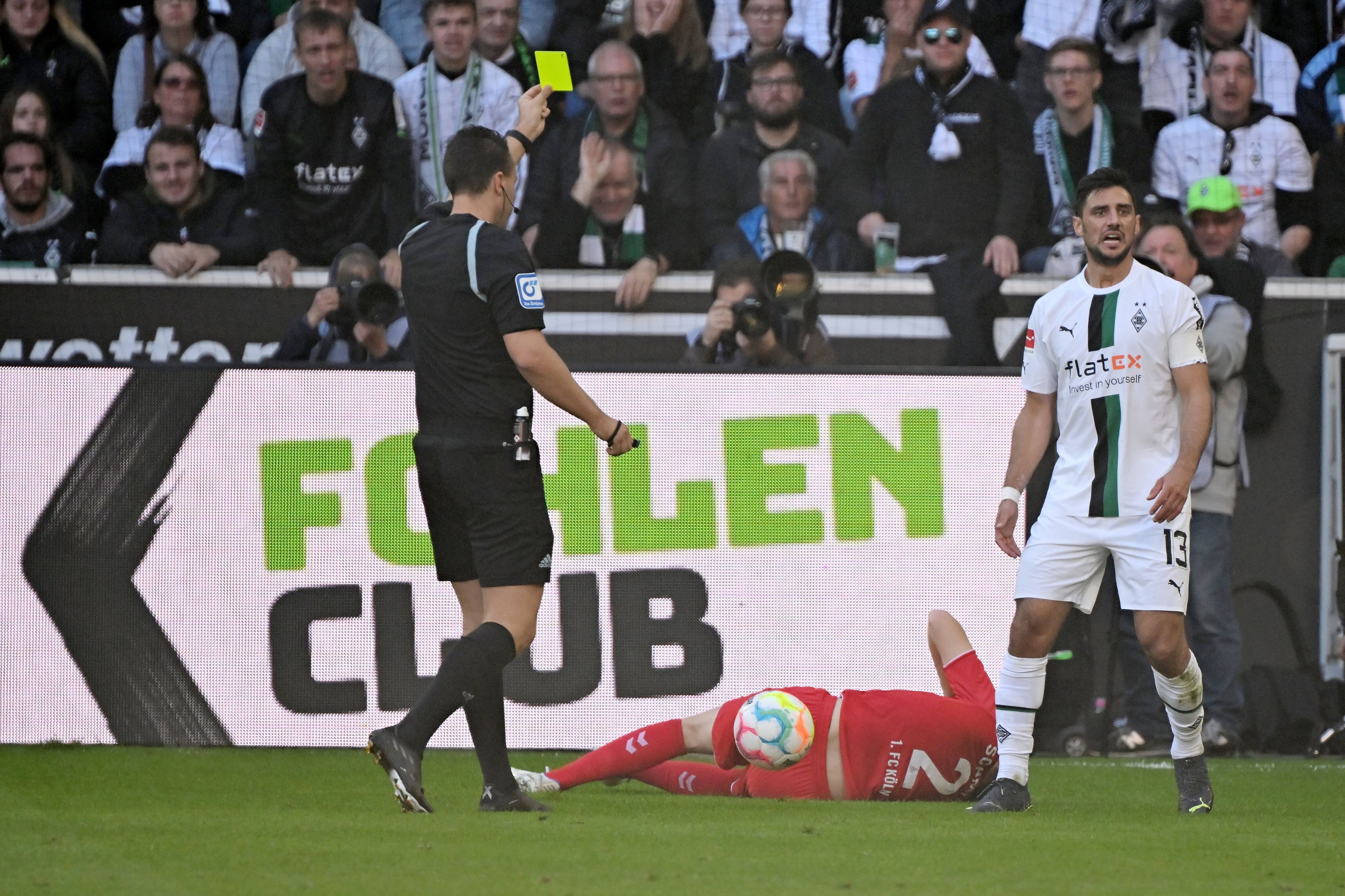 Schiedsrichter Sven Jablonski zeigt Kapitän Lars Stindl von Borussia Mönchengladbach im Bundesliga-Spiel gegen den 1. FC Köln am 9. Oktober 2022 die Gelbe Karte.