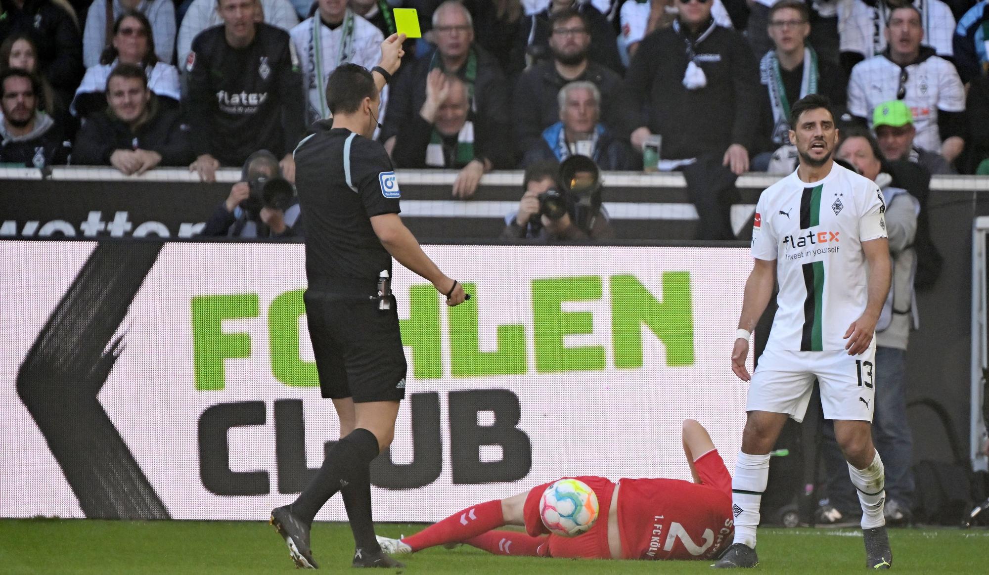 Schiedsrichter Sven Jablonski zeigt Kapitän Lars Stindl von Borussia Mönchengladbach im Bundesliga-Spiel gegen den 1. FC Köln am 9. Oktober 2022 die Gelbe Karte.