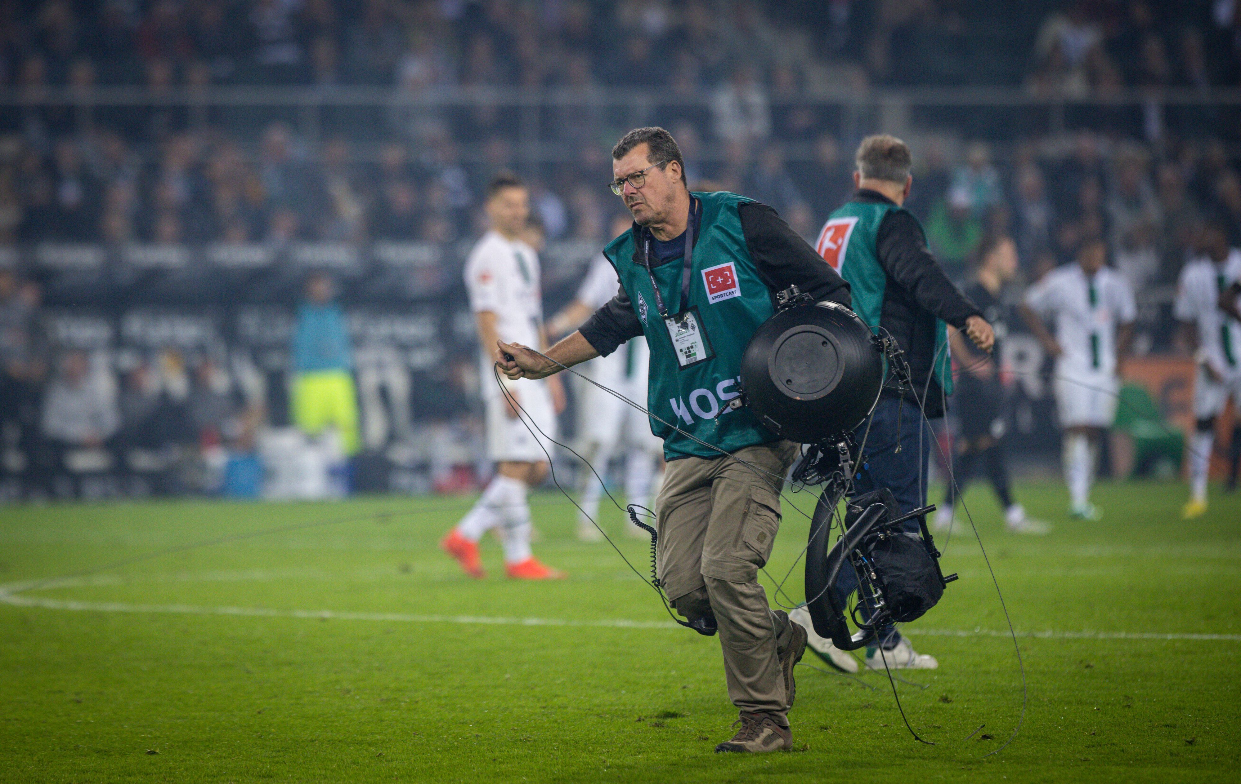 Ein Techniker trägt die defekte Spidercam vom Spielfeld, geschehen beim Bundesliga-Spiel Borussia Mönchengladbach gegen Eintracht Frankfurt im Borussia-Park am 22. Oktober 2022.