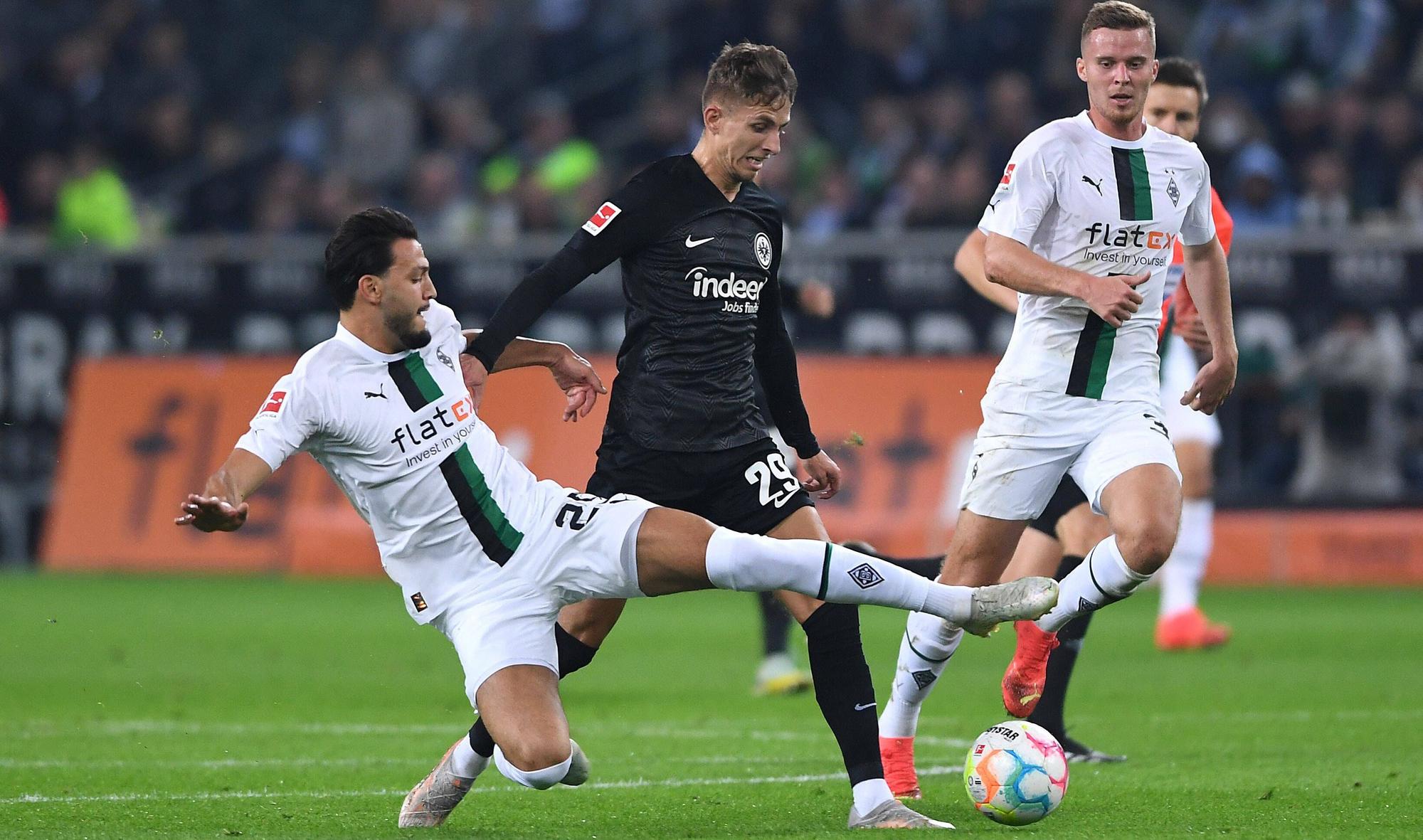 Ramy Bensebaini (l.) und Nico Elvedi (r.) von Borussia Mönchengladbach am 22. Oktober 2022 im Zweikampf mit Jesper Lindström von Eintracht Frankfurt. Bensebaini grätscht zum Ball.