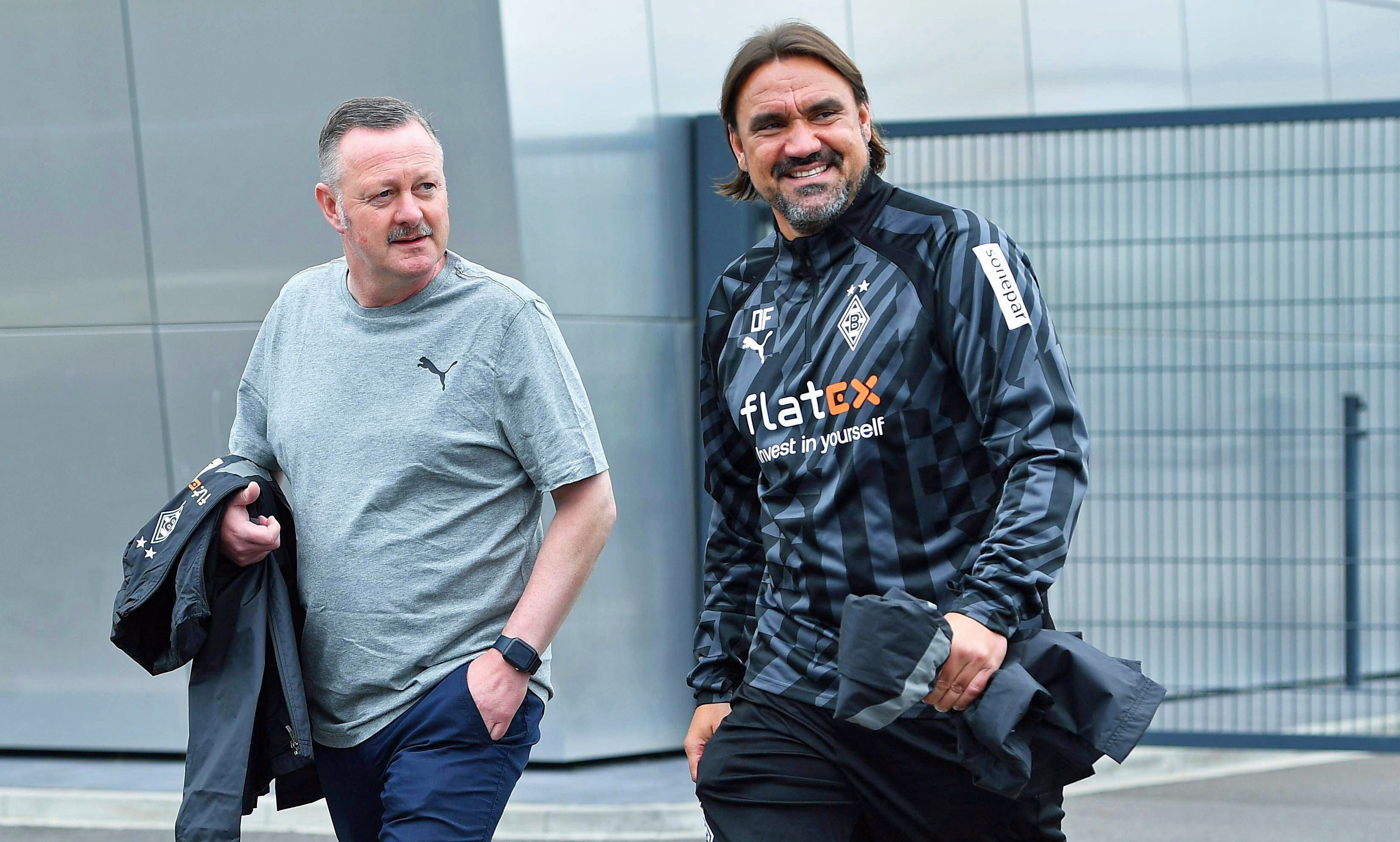 Gladbach-Manager Roland Virkus (l.) und Borussia-Trainer Daniel Farke (r.), hier zu sehen am 26. Juni 2022 im Borussia-Park. Die beiden gehen Richtung Fohlenplatz und lächeln.