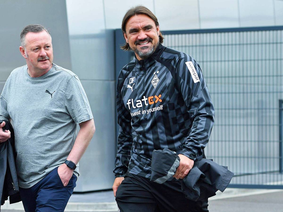 Gladbach-Manager Roland Virkus (l.) und Borussia-Trainer Daniel Farke (r.), hier zu sehen am 26. Juni 2022 im Borussia-Park. Die beiden gehen Richtung Fohlenplatz und lächeln.