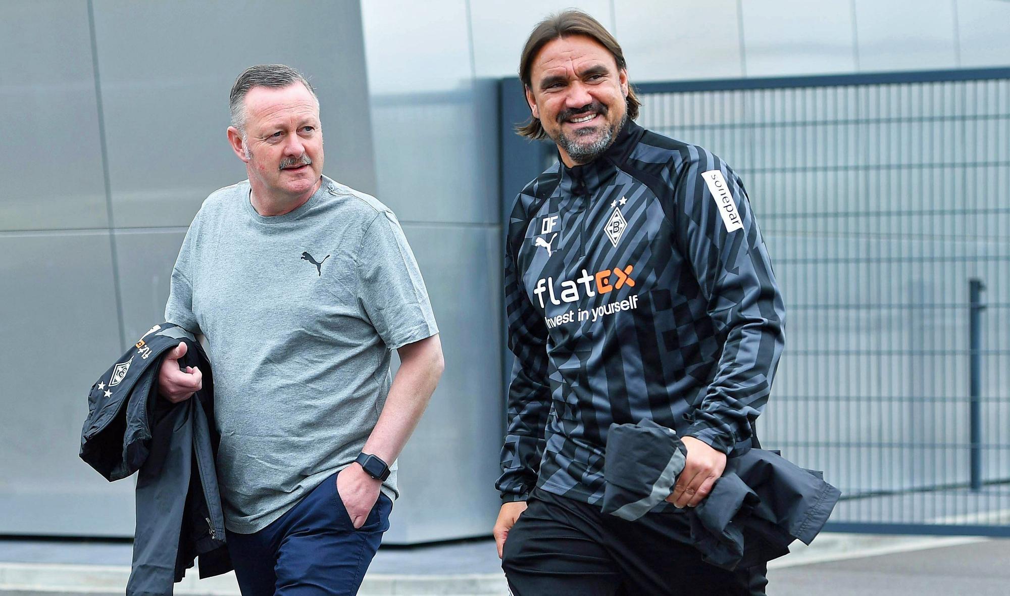 Gladbach-Manager Roland Virkus (l.) und Borussia-Trainer Daniel Farke (r.), hier zu sehen am 26. Juni 2022 im Borussia-Park. Die beiden gehen Richtung Fohlenplatz und lächeln.