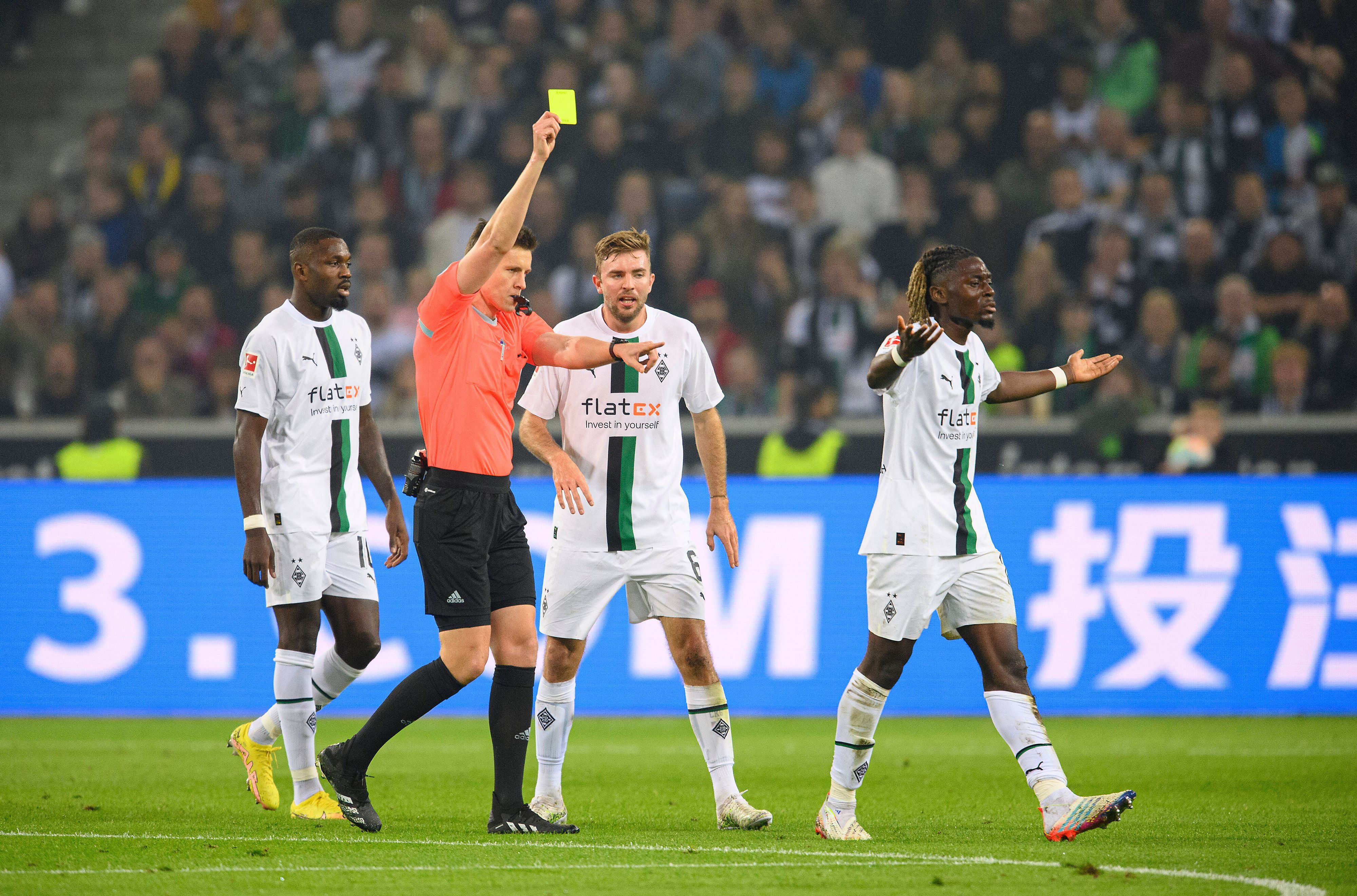Schiedsrichter Daniel Siebert zeigt Manu Koné (r.) von Borussia Mönchengladbach die Gelbe Karte im Bundesliga-Topspiel (22. Oktober 2022) gegen Eintracht Frankfurt. Koné ist damit nicht einverstanden und gestikuliert.
