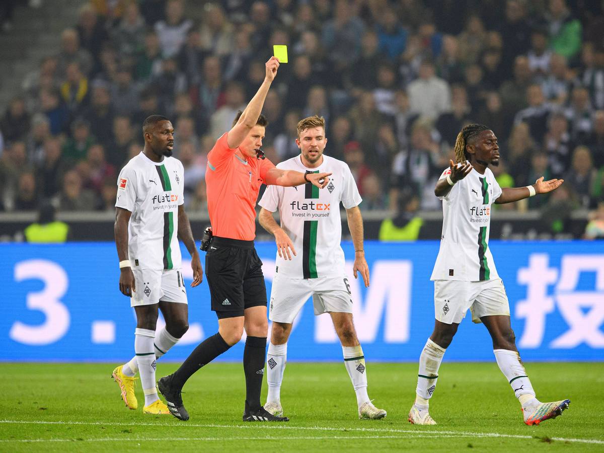 Schiedsrichter Daniel Siebert zeigt Manu Koné (r.) von Borussia Mönchengladbach die Gelbe Karte im Bundesliga-Topspiel (22. Oktober 2022) gegen Eintracht Frankfurt. Koné ist damit nicht einverstanden und gestikuliert.