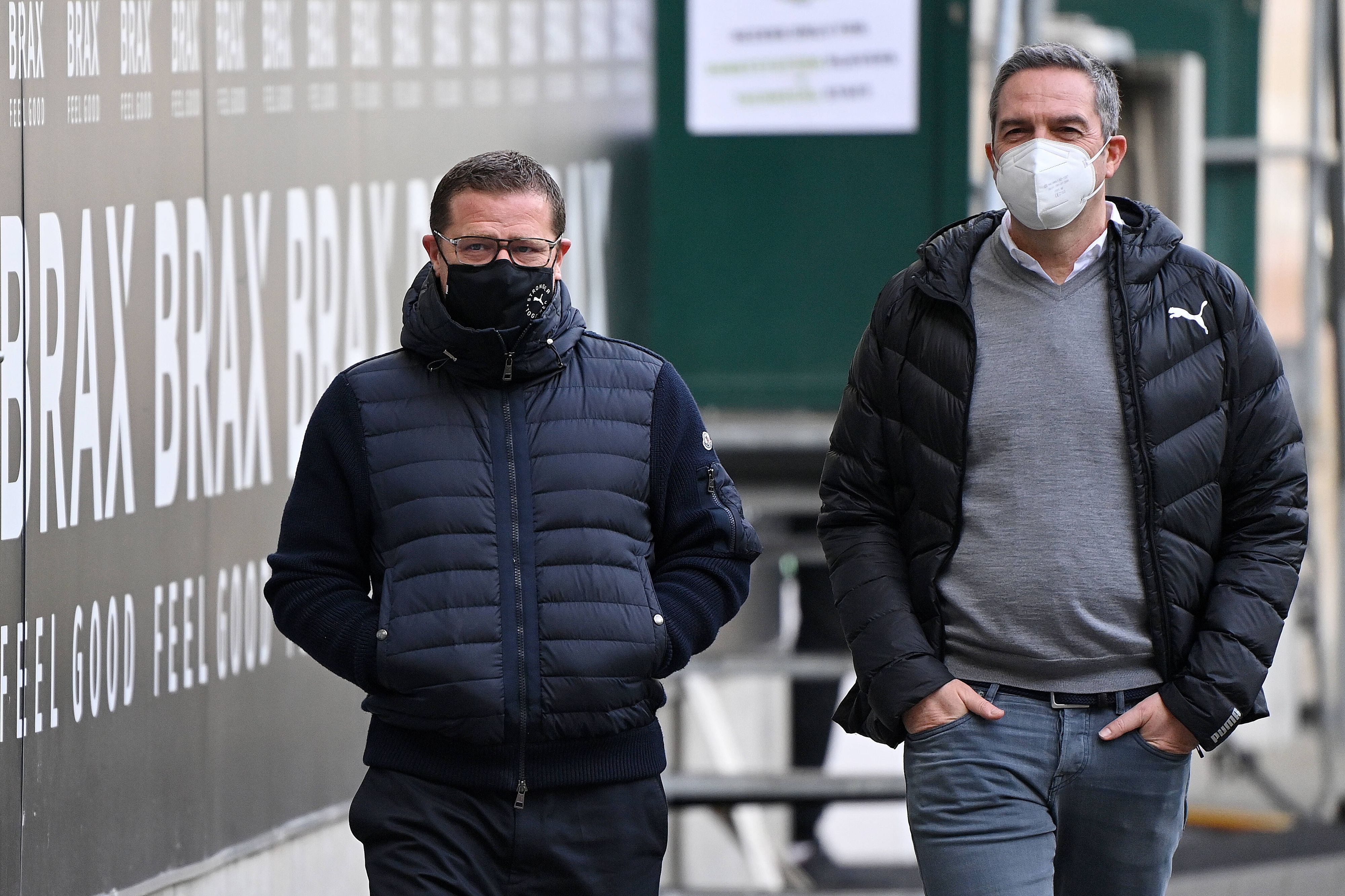 Max Eberl (l.) und Markus Aretz (r.) laufen mit Masken nebeneinander.