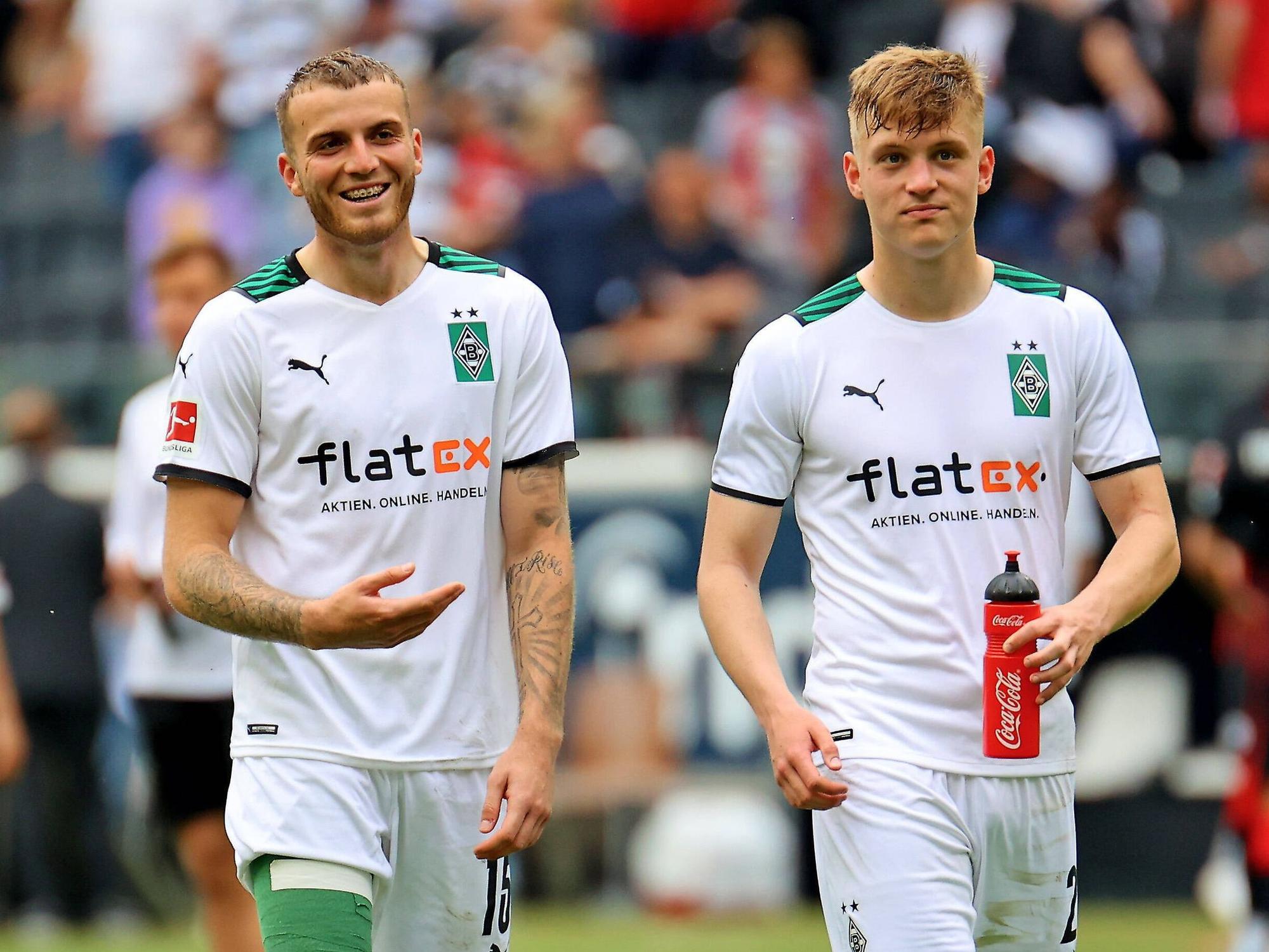 Jordan Beyer (l.) und Luca Netz (r.) gemeinsam auf dem Rasen nach dem Spiel von Borussia Mönchengladbach bei Eintracht Frankfurt am 8. Mai 2022.
