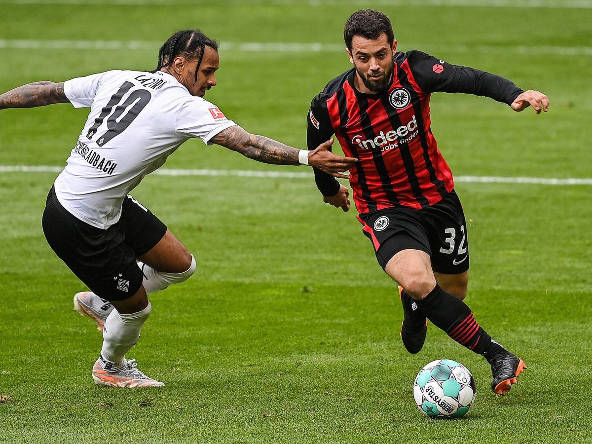 Amin Younes (r.) will im Spiel von Eintracht Frankfurt gegen Borussia Mönchengladbach am 18. April 2021 den Ball gegen Valentino Lazaro (l.) behaupten.
