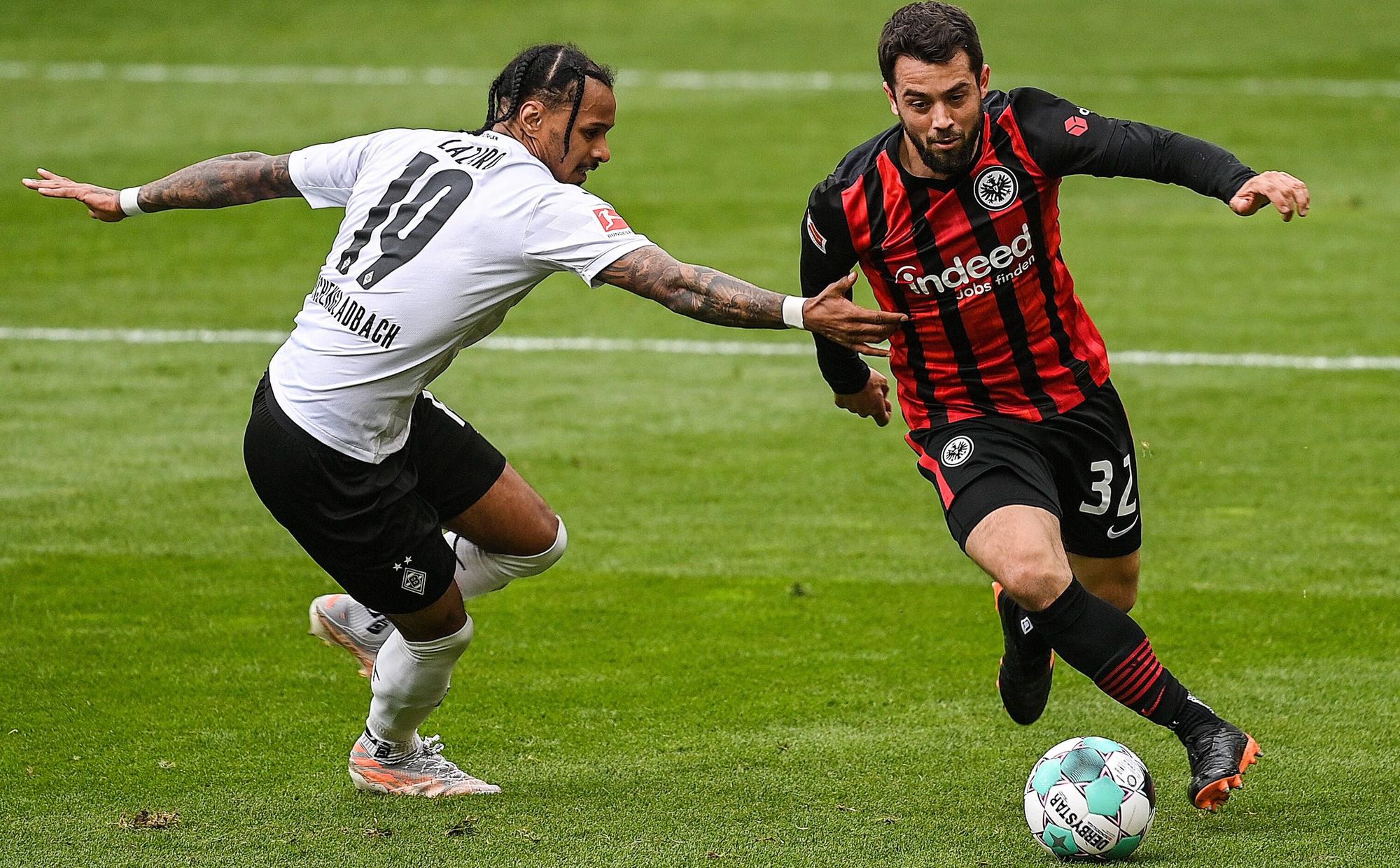 Amin Younes (r.) will im Spiel von Eintracht Frankfurt gegen Borussia Mönchengladbach am 18. April 2021 den Ball gegen Valentino Lazaro (l.) behaupten.