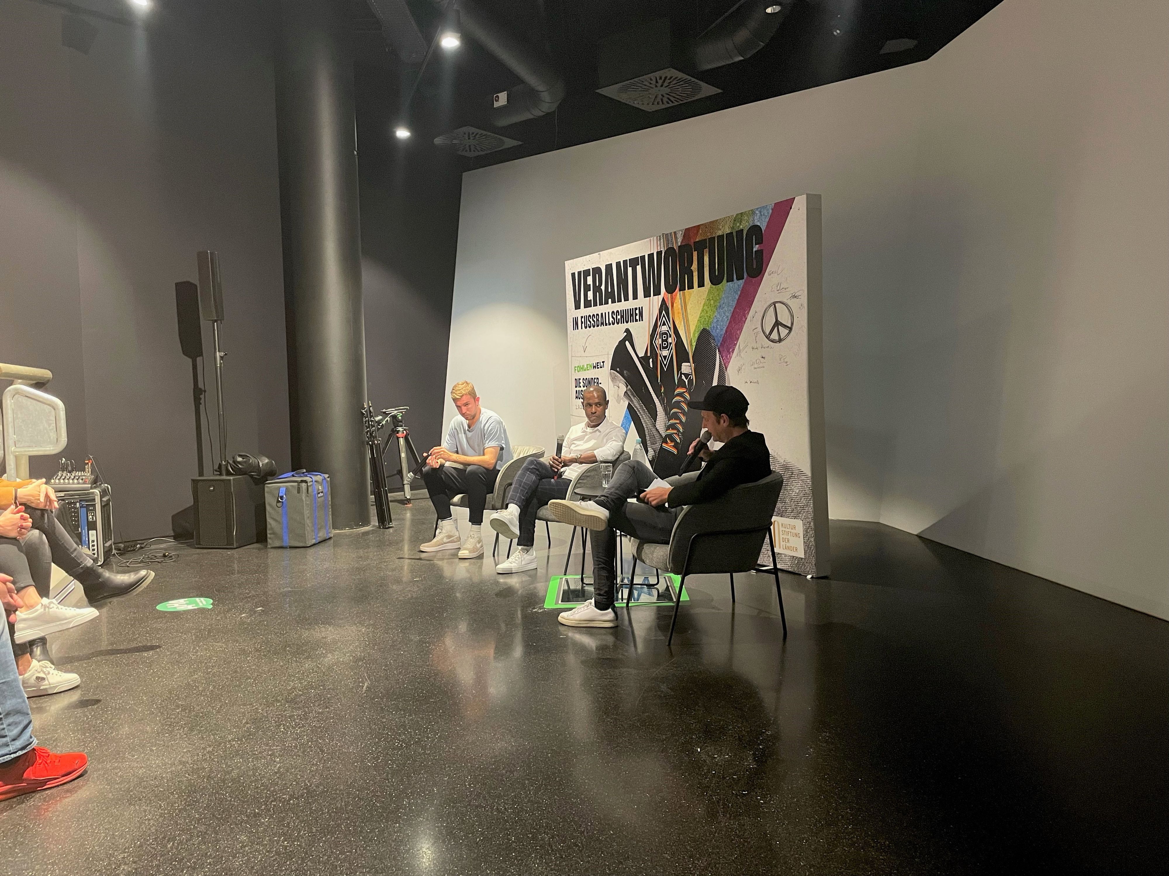 Christoph Kramer (l.) sitzt bei einer Talk-Veranstaltung von Borussia Mönchengladbach neben Chiquinho (M.) und Moderator Torsten Knippertz (r.).