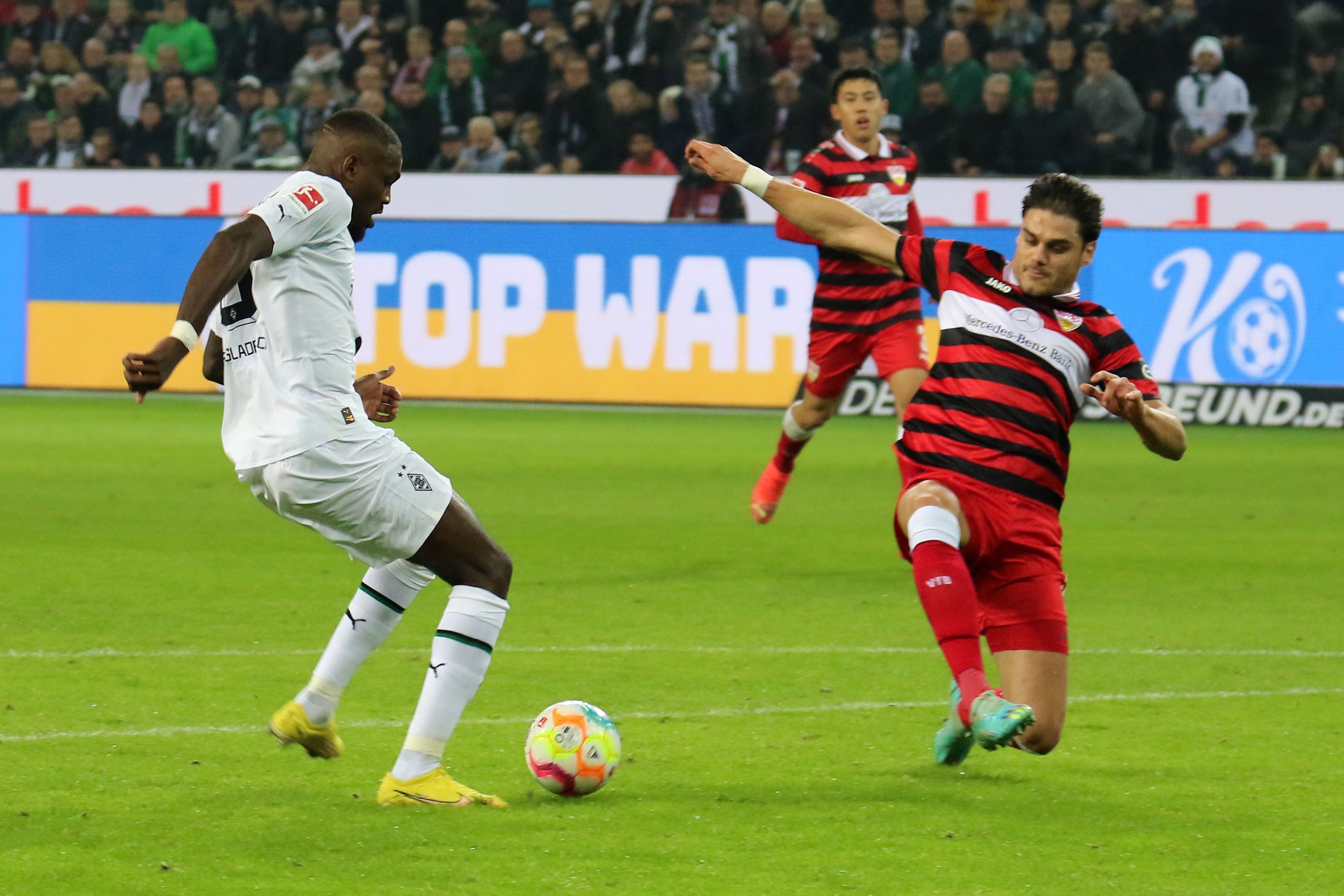 Marcus Thuram von Borussia Mönchengladbach (l.) trifft am 4. November 2022 zum zwischenzeitlichen 2:0 für seine Mannschaft gegen den VfB Stuttgart. Konstantinos Mavropanos (r.) kann nicht mehr retten.