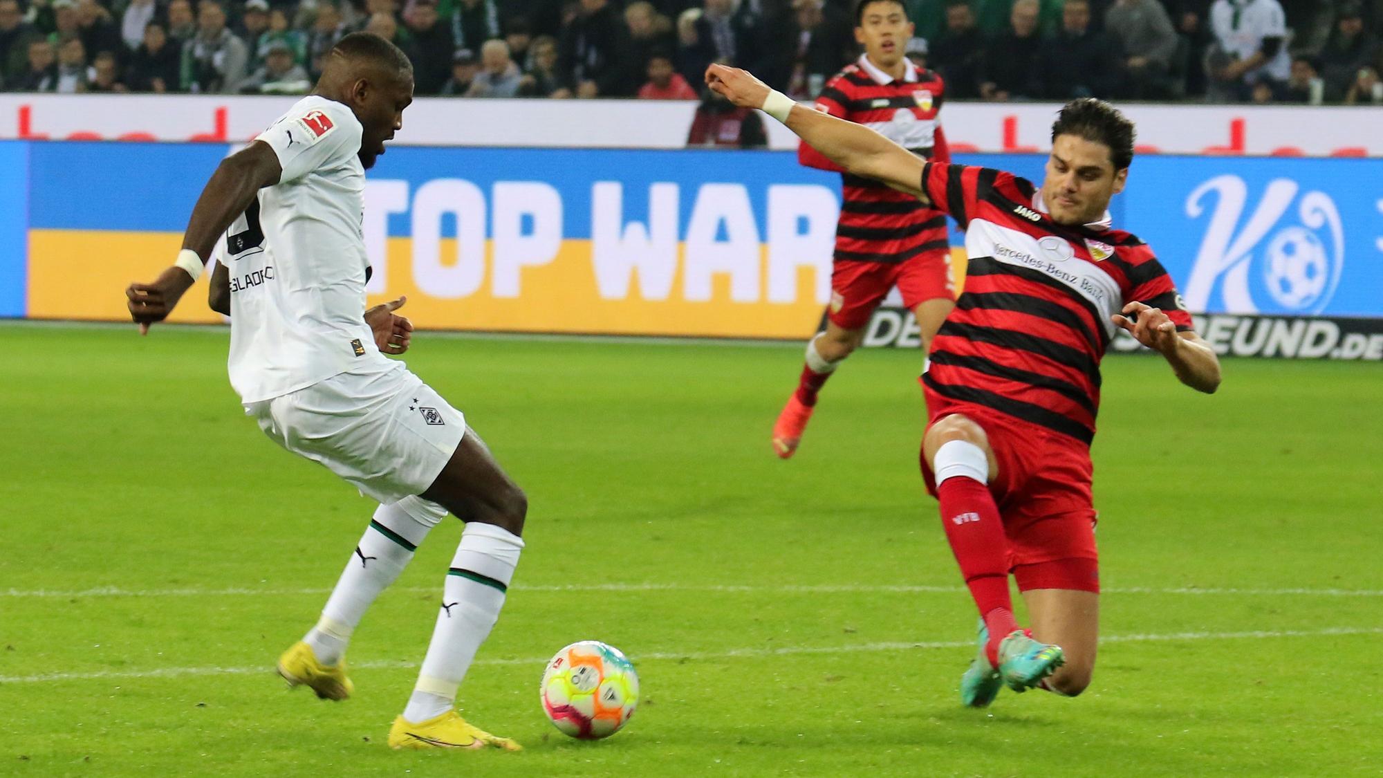 Marcus Thuram von Borussia Mönchengladbach (l.) trifft am 4. November 2022 zum zwischenzeitlichen 2:0 für seine Mannschaft gegen den VfB Stuttgart. Konstantinos Mavropanos (r.) kann nicht mehr retten.