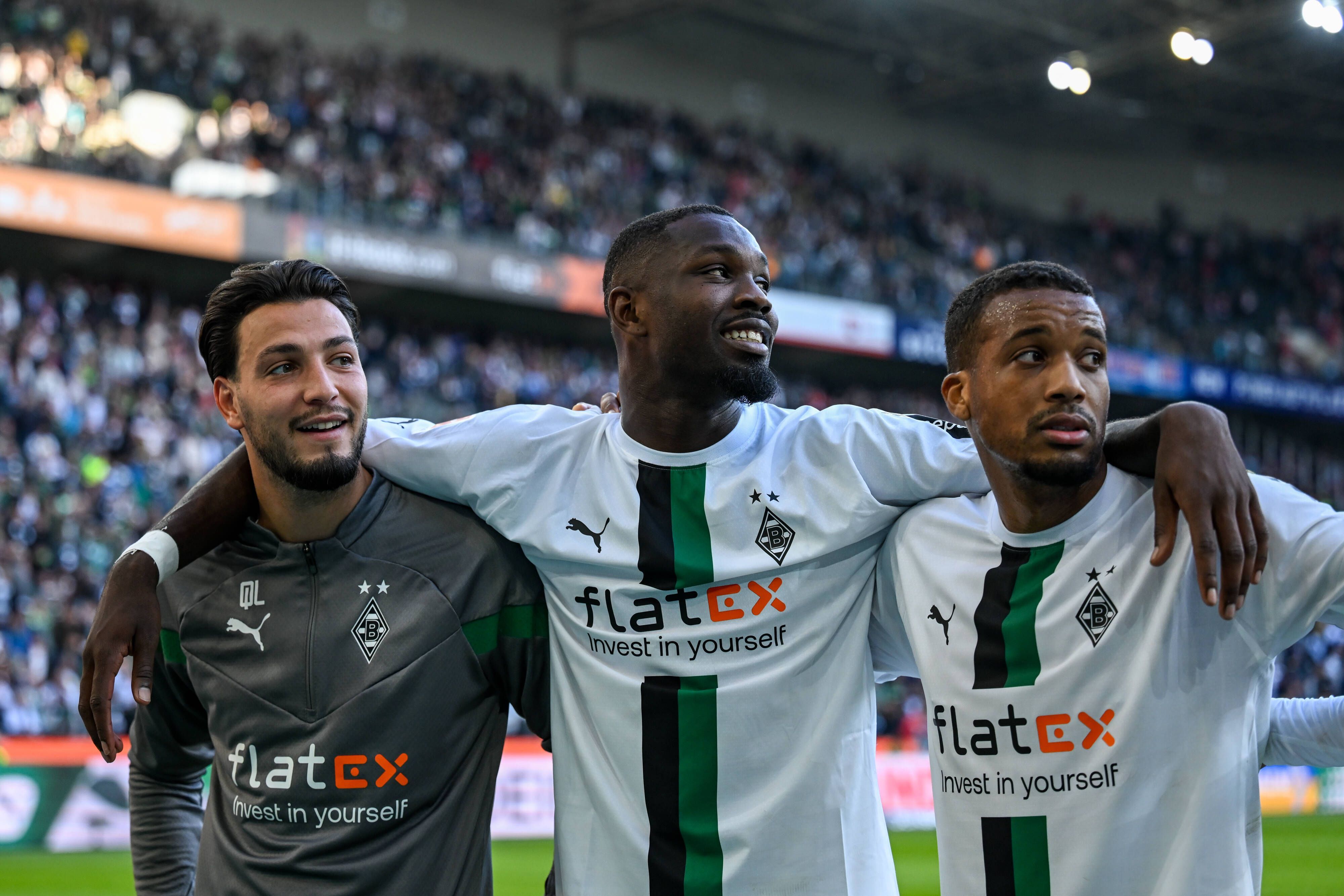 Arm in Arm! Ramy Bensebaini (l.), Marcus Thuram (m.) und Alassane Plea (r.) feiern den Sieg von Borussia Mönchengladbach gegen den 1. FC Köln am 9. Oktober 2022.