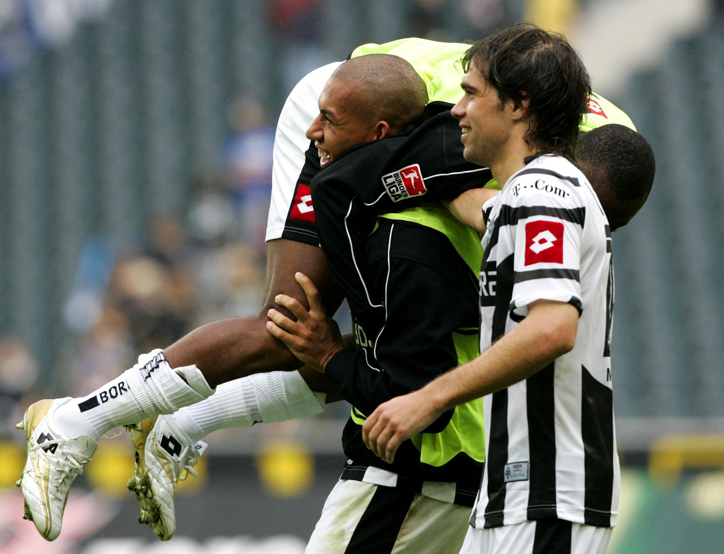 Federico Insúa (r.) freut sich nach einem Sieg von Borussia Mönchengladbach über Arminia Bielefeld mit Torschütze Kahe (l.), der Nando Rafael schultert.