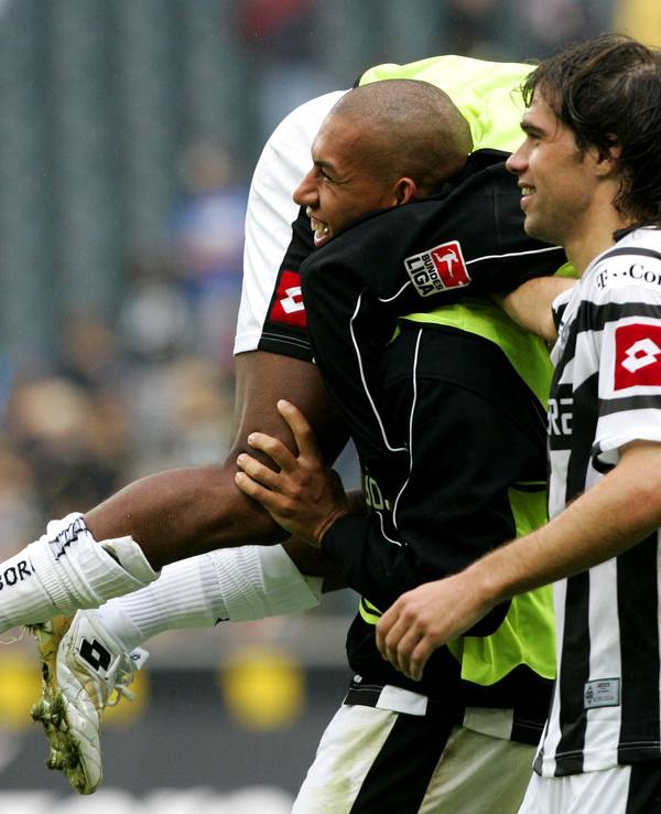 Federico Insúa (r.) freut sich nach einem Sieg von Borussia Mönchengladbach über Arminia Bielefeld mit Torschütze Kahe (l.), der Nando Rafael schultert.