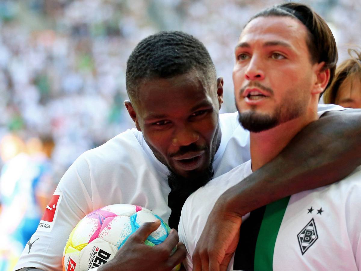 Gladbach-Profi Ramy Bensebaini (r.) bejubelt gemeinsam mit Team-Kollege Marcus Thuram (l.) einen Treffer in der Fußball-Bundesliga. Auf diesem Foto sind die beiden Borussia-Spieler am 6. August 2022 im Borussia-Park zu sehen. Thuram umarmt Bensebaini.