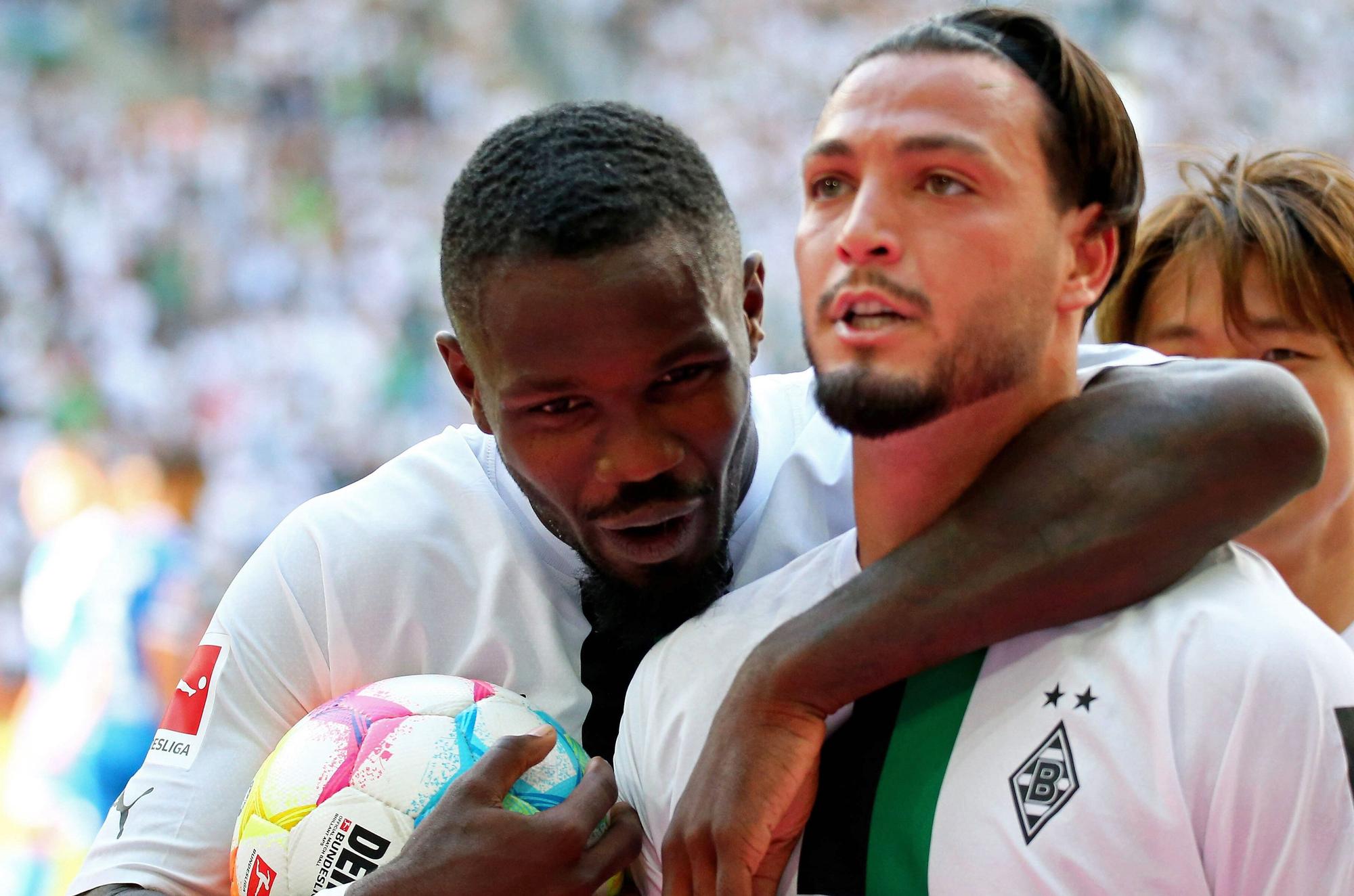 Gladbach-Profi Ramy Bensebaini (r.) bejubelt gemeinsam mit Team-Kollege Marcus Thuram (l.) einen Treffer in der Fußball-Bundesliga. Auf diesem Foto sind die beiden Borussia-Spieler am 6. August 2022 im Borussia-Park zu sehen. Thuram umarmt Bensebaini.