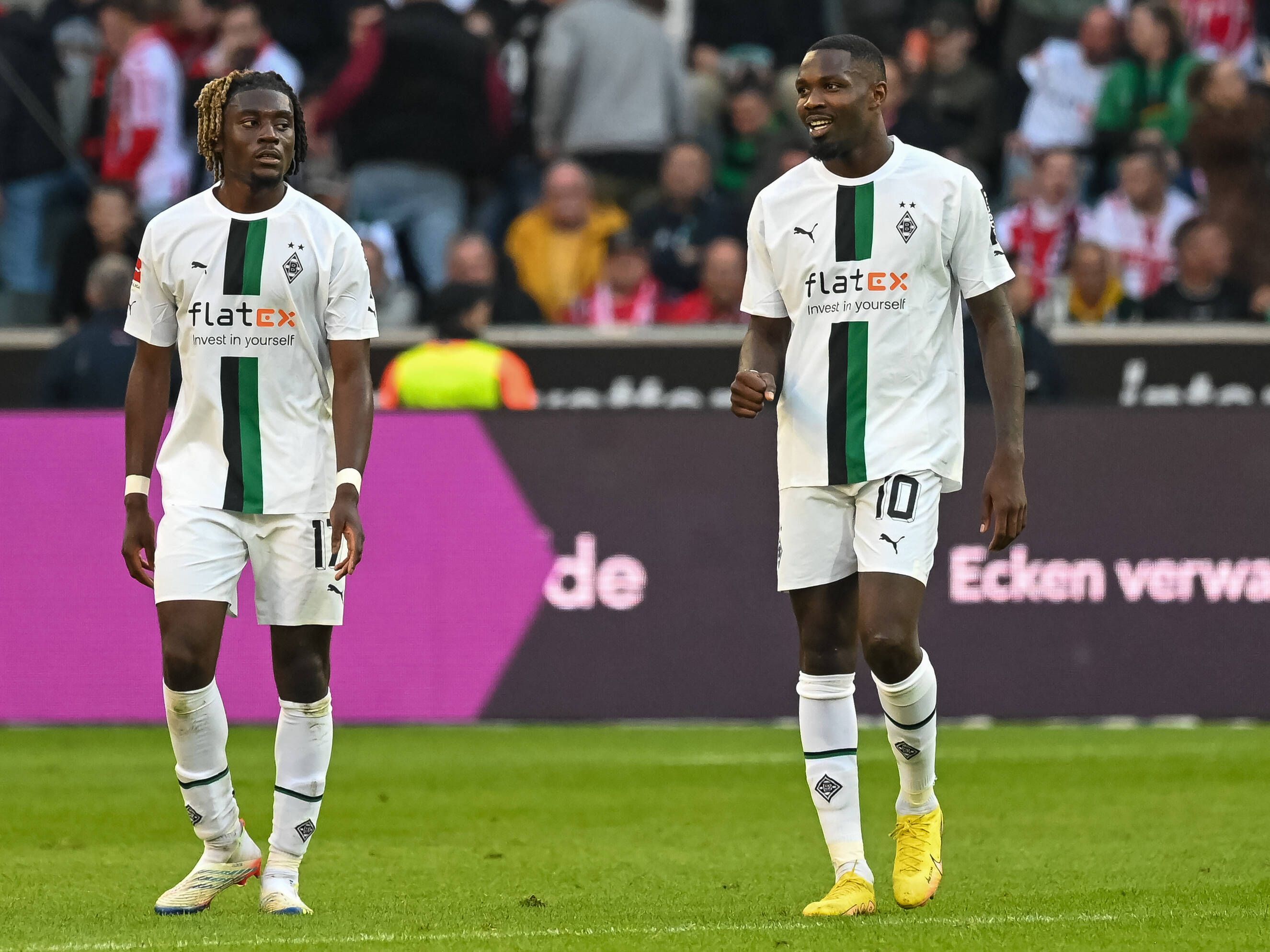 Marcus Thuram (r.) von Borussia Mönchengladbach ballt beim Bundesliga-Spiel gegen den 1. FC Köln am 9. Oktober 2022 die Faust, Mitspieler Manu Koné (l.) schaut in Thurams Richtung.